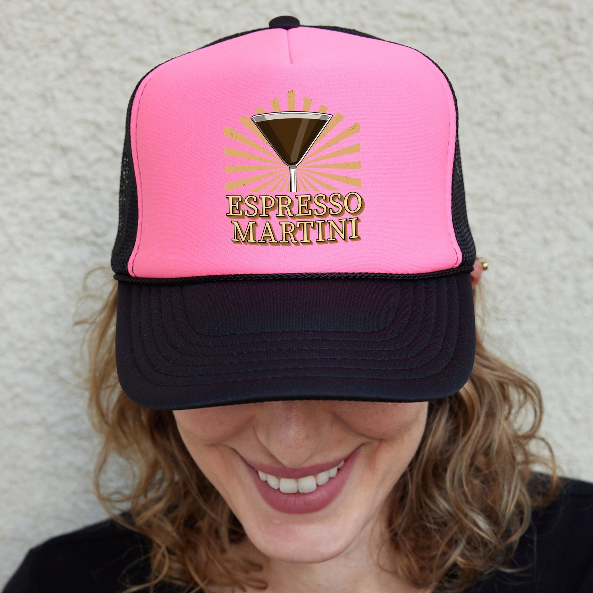 a woman wearing a pink and black trucker hat