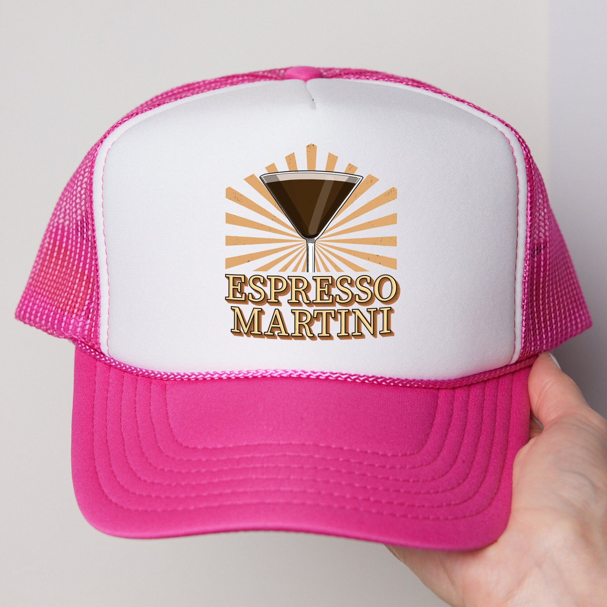 a person holding a pink and white trucker hat