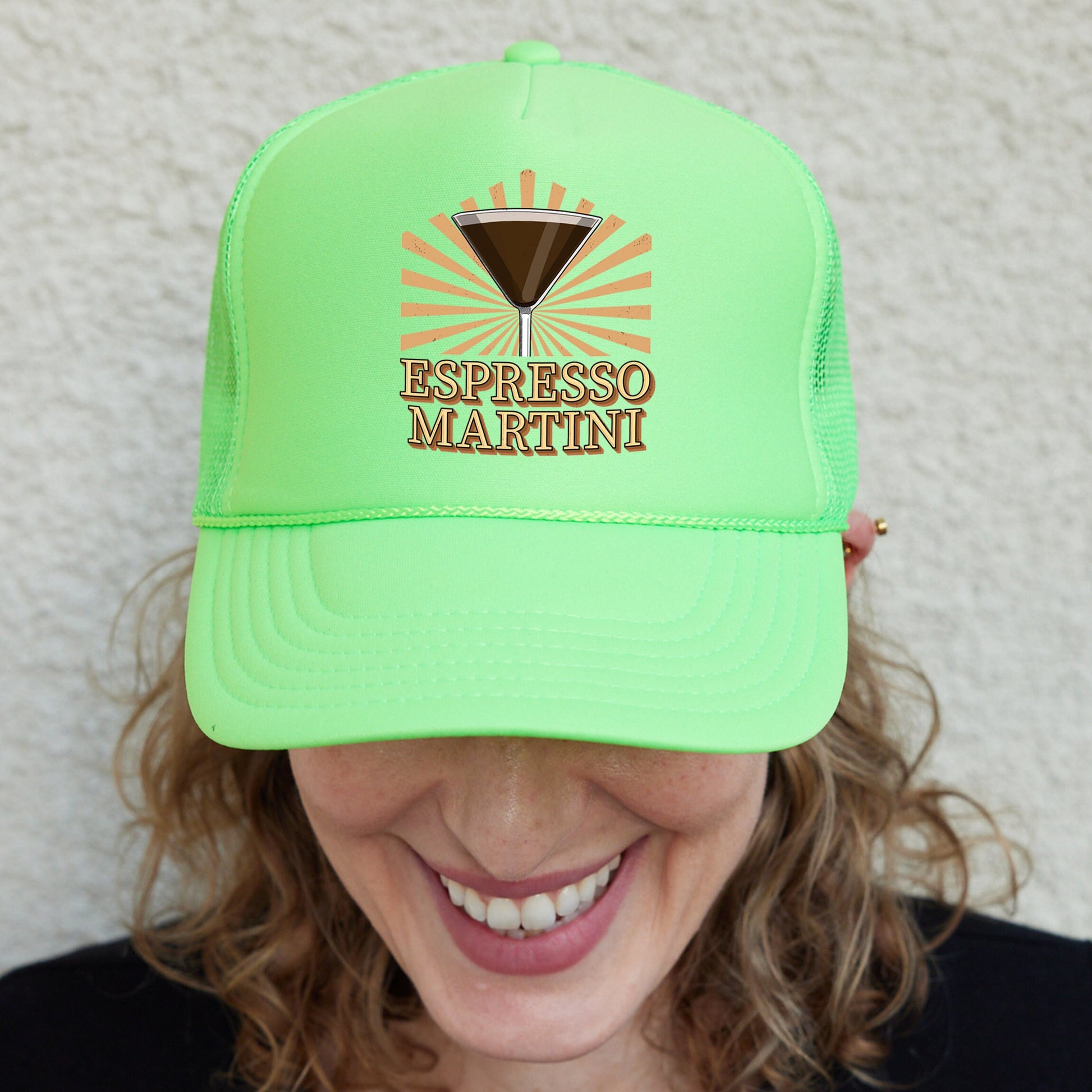 a smiling woman wearing a green hat with a martini on it
