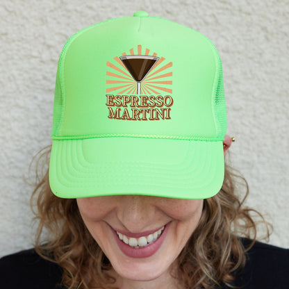 a smiling woman wearing a green hat with a martini on it