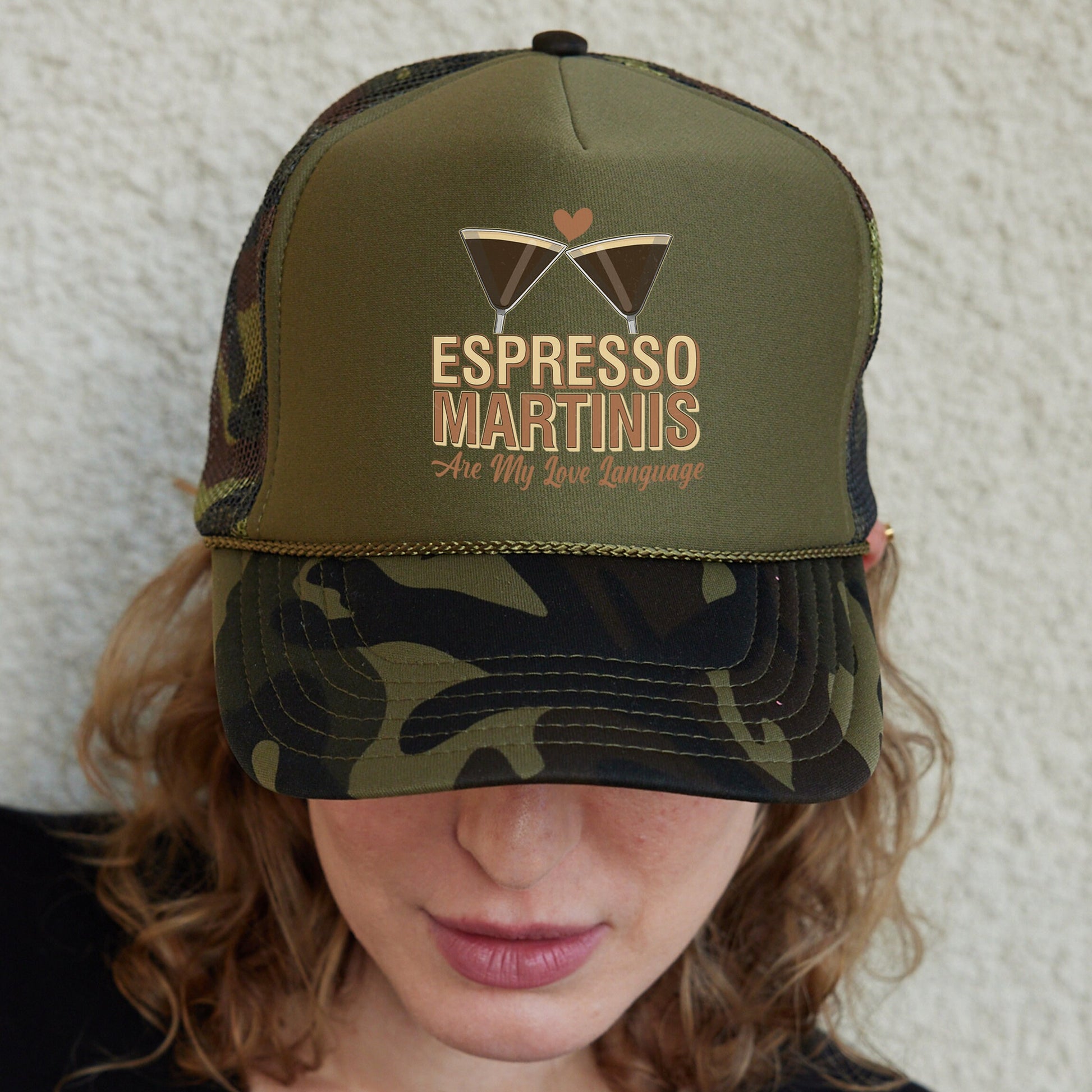 a woman wearing a camo trucker hat with the words espresso martini