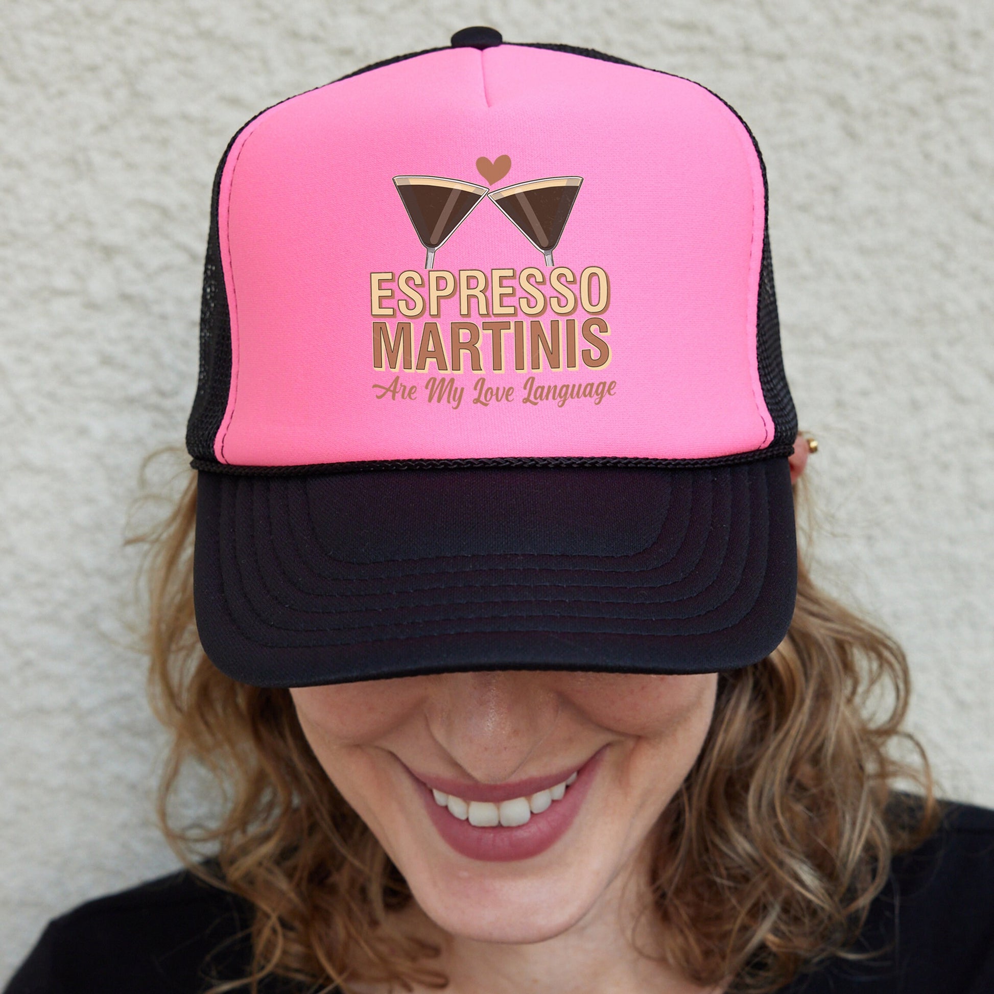 a woman wearing a pink and black trucker hat