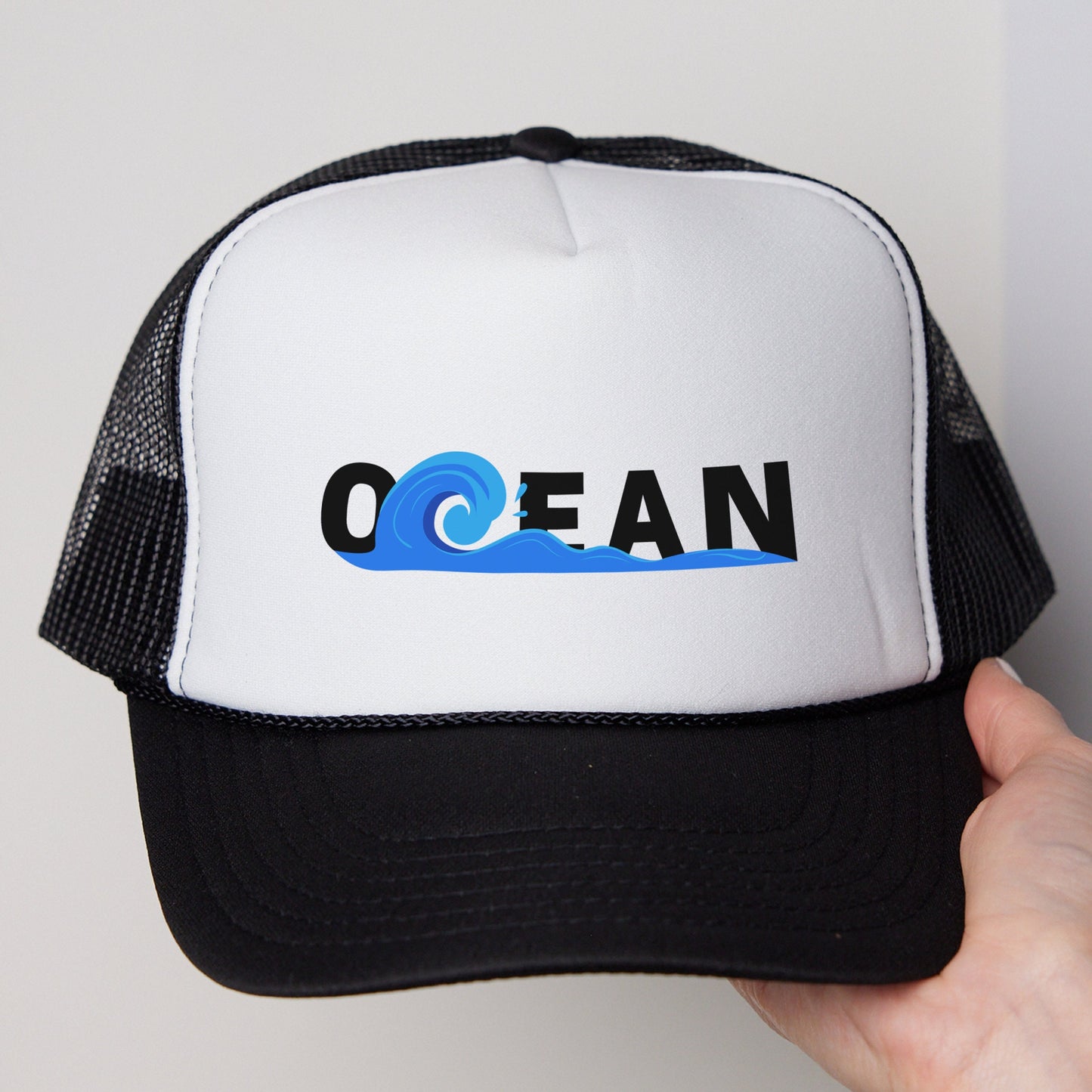 a white and black trucker hat with the word ocean on it