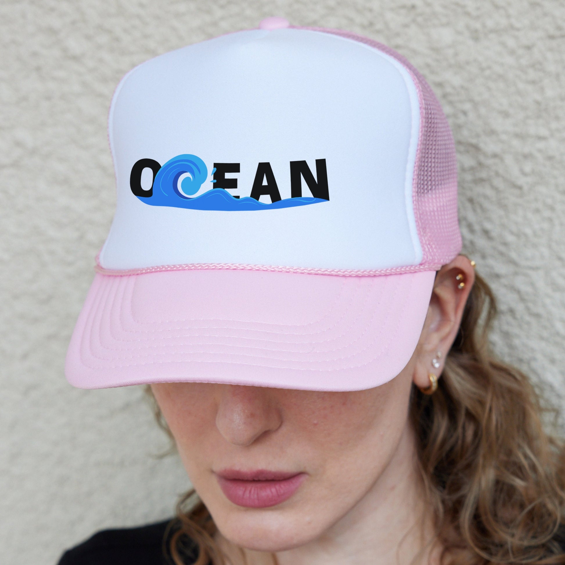 a woman wearing a pink and white trucker hat