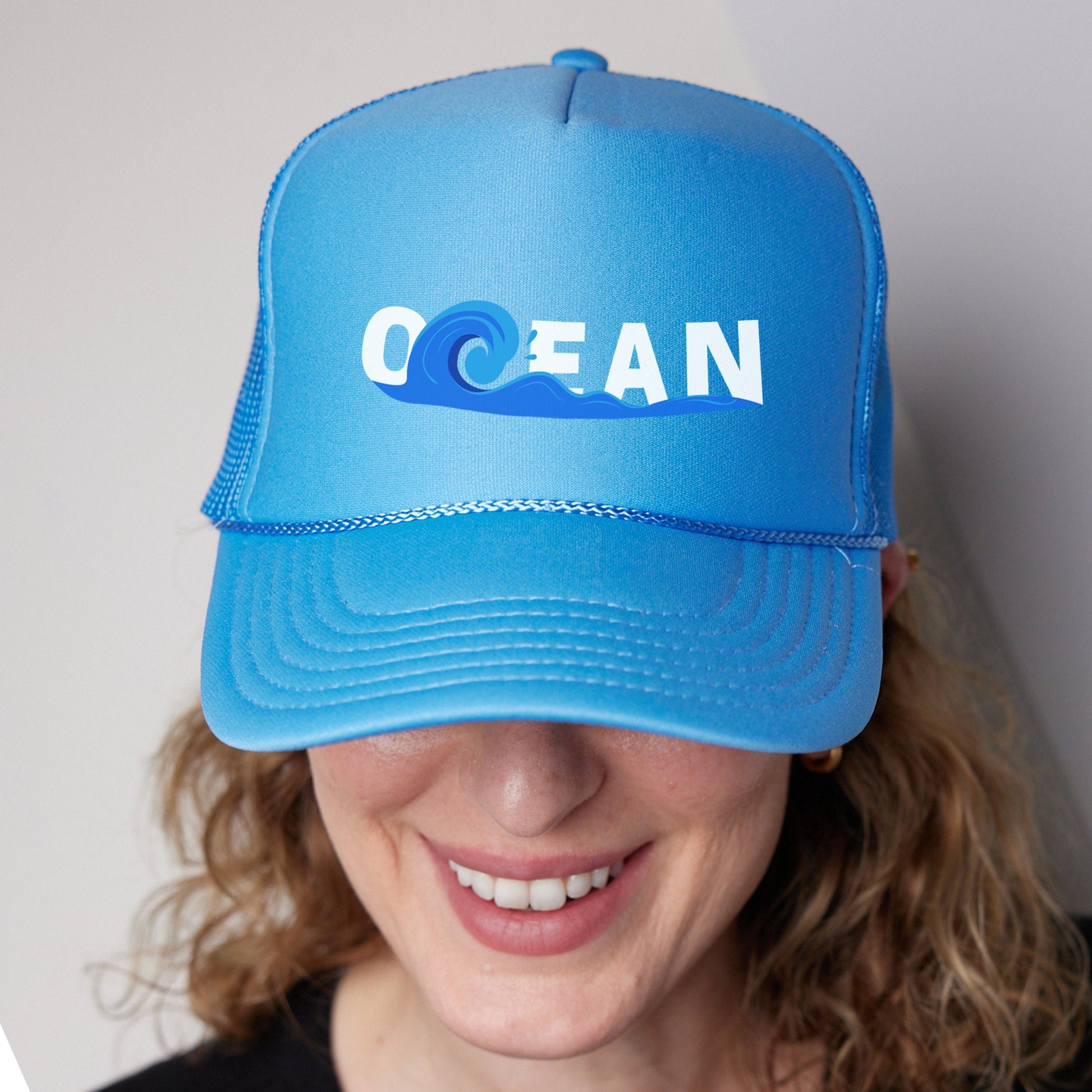 a woman wearing a blue hat with the word ocean on it