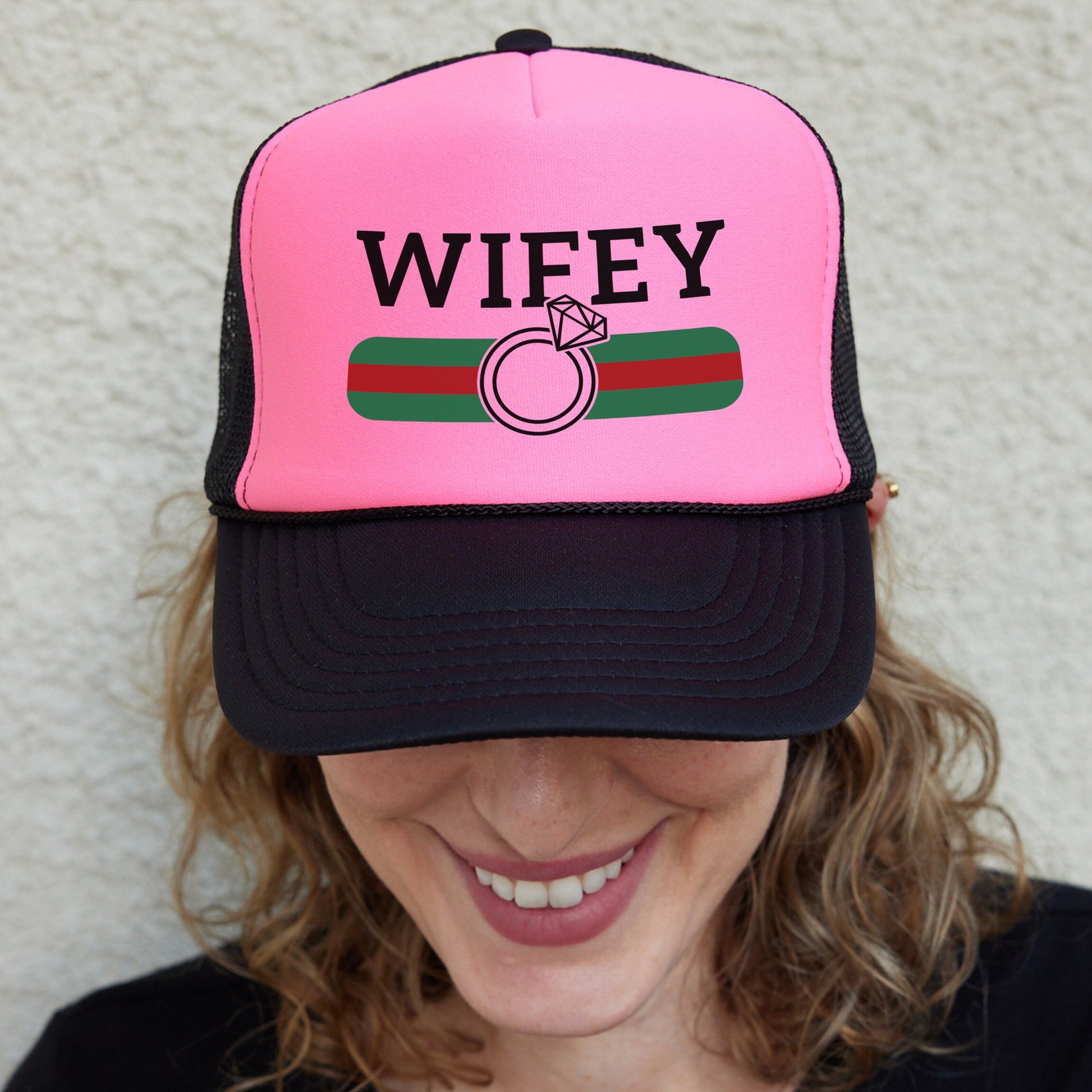 a woman wearing a pink and black trucker hat