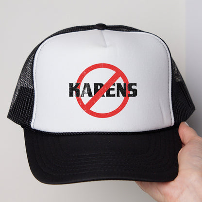 a hand holding a black and white trucker hat