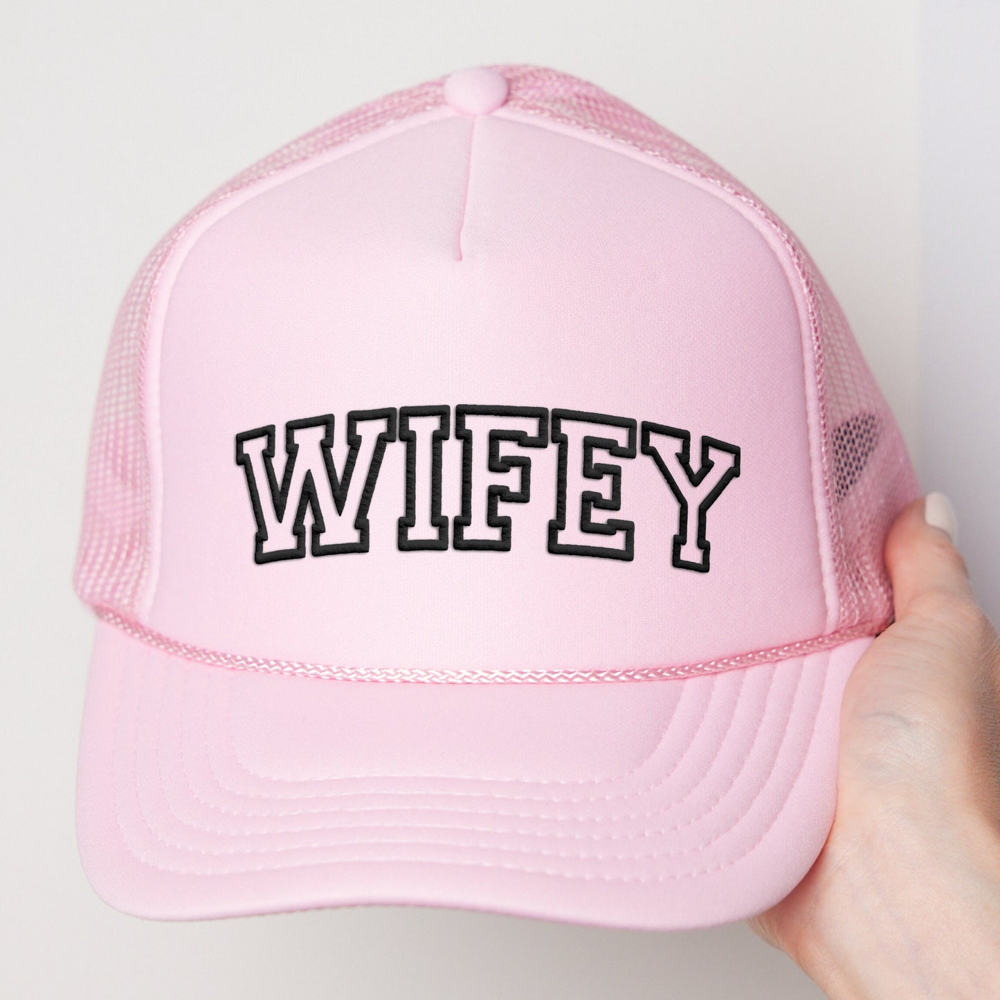 a pink trucker hat with the word wife printed on it