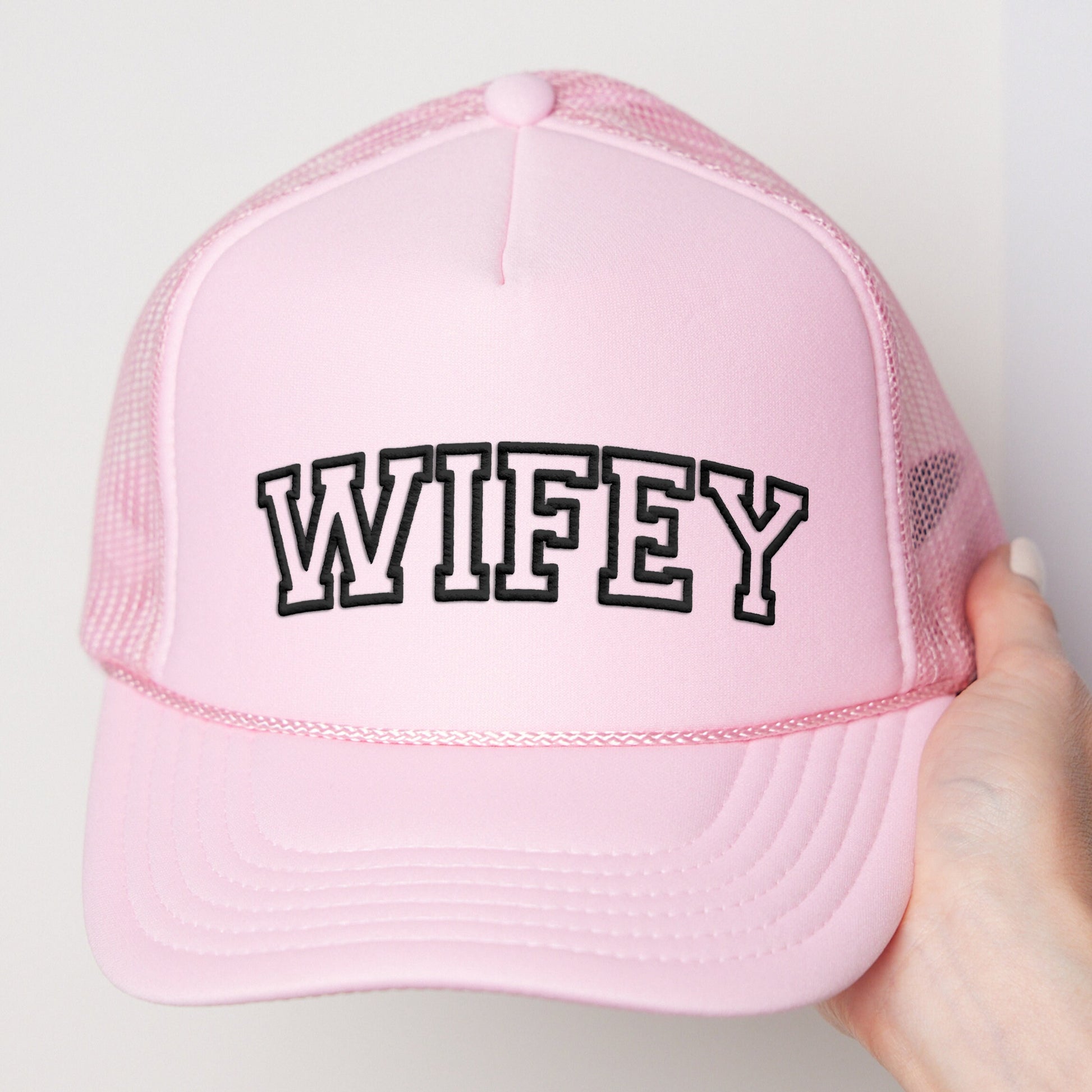 a pink trucker hat with the word wife printed on it