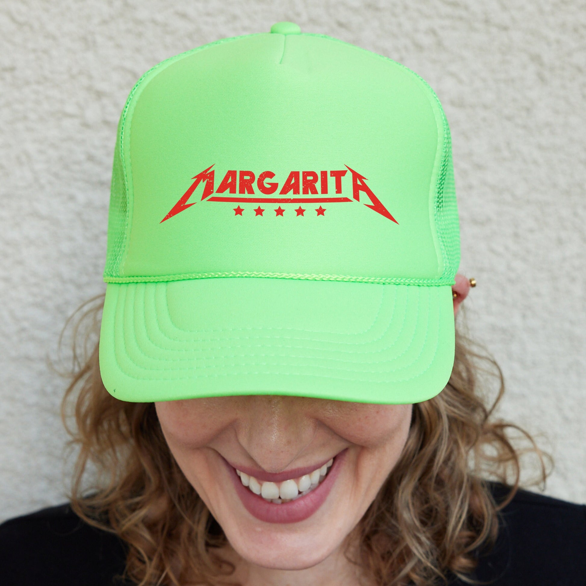 a smiling woman wearing a neon green hat