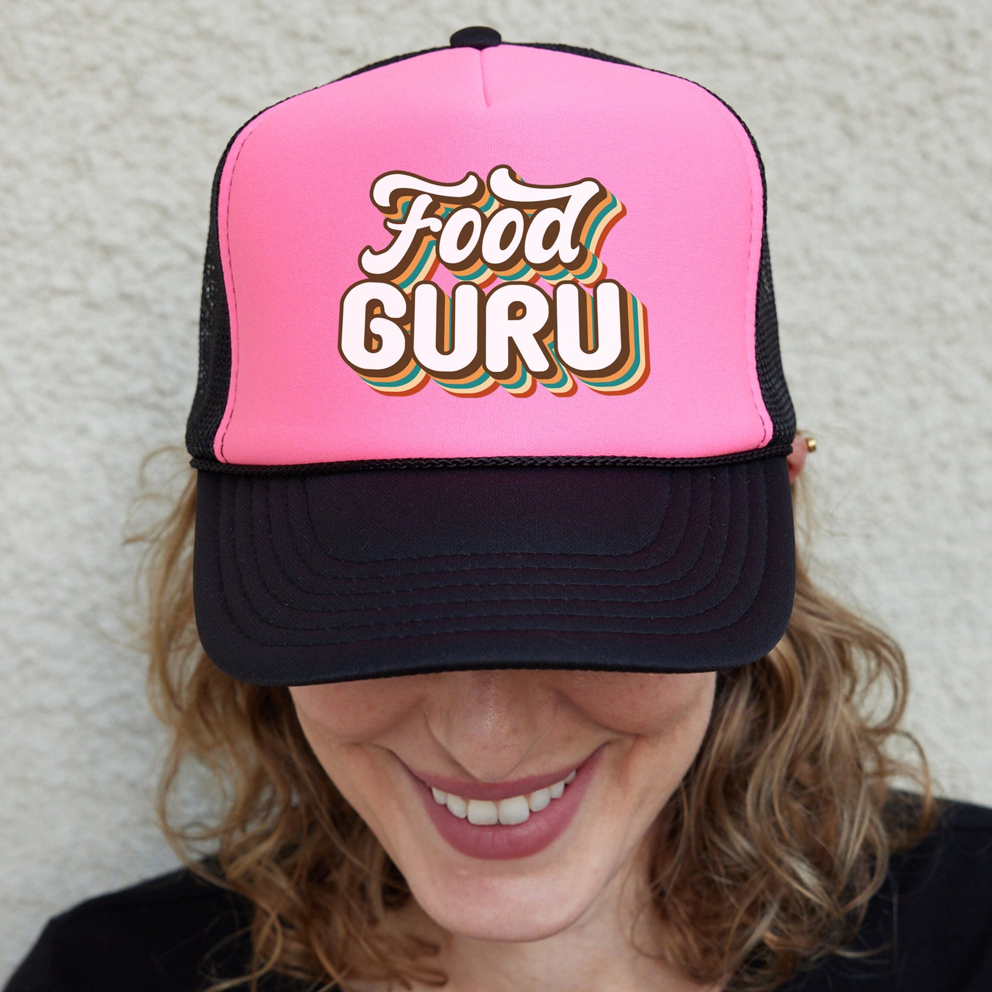 a woman wearing a pink and black trucker hat