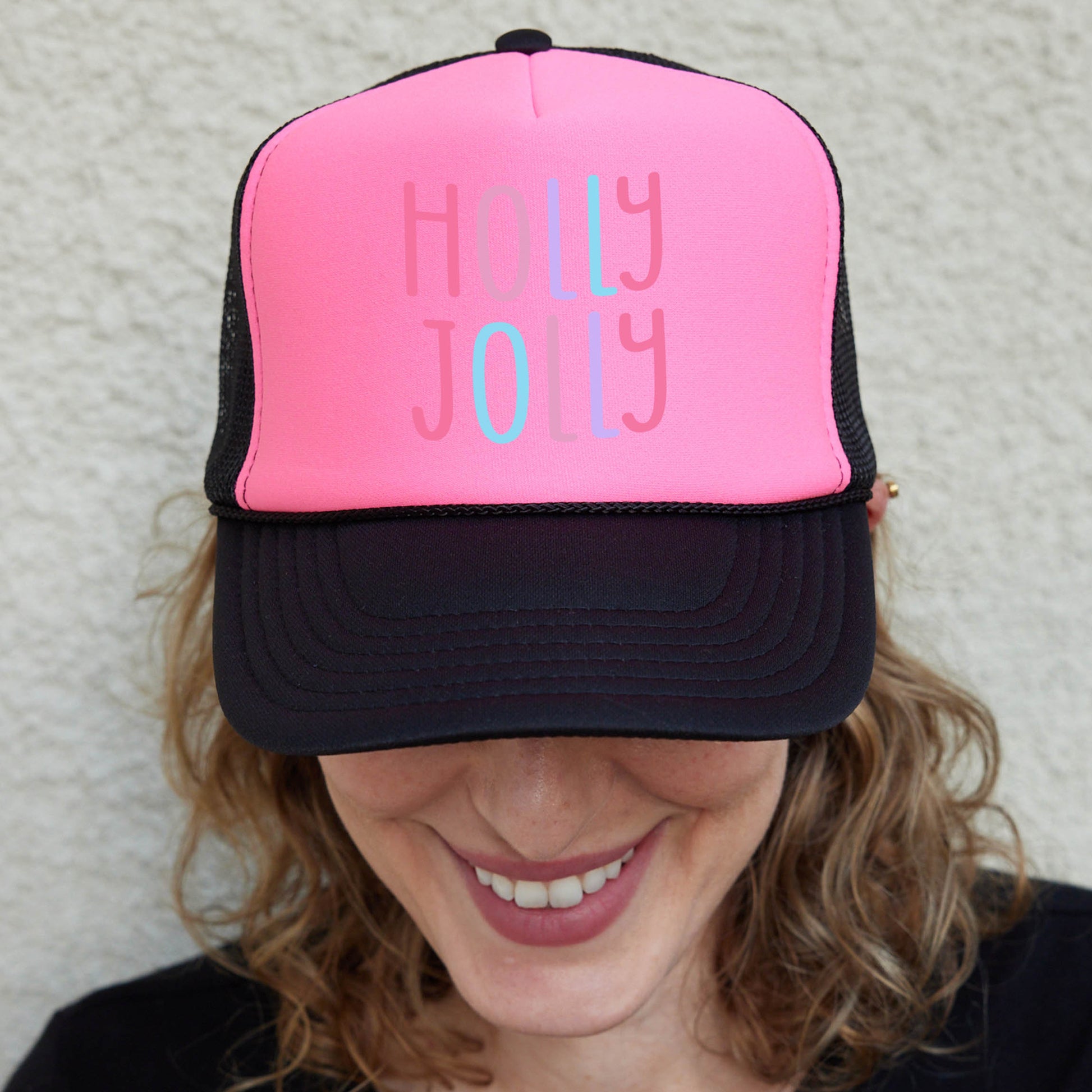 a woman wearing a pink and black trucker hat