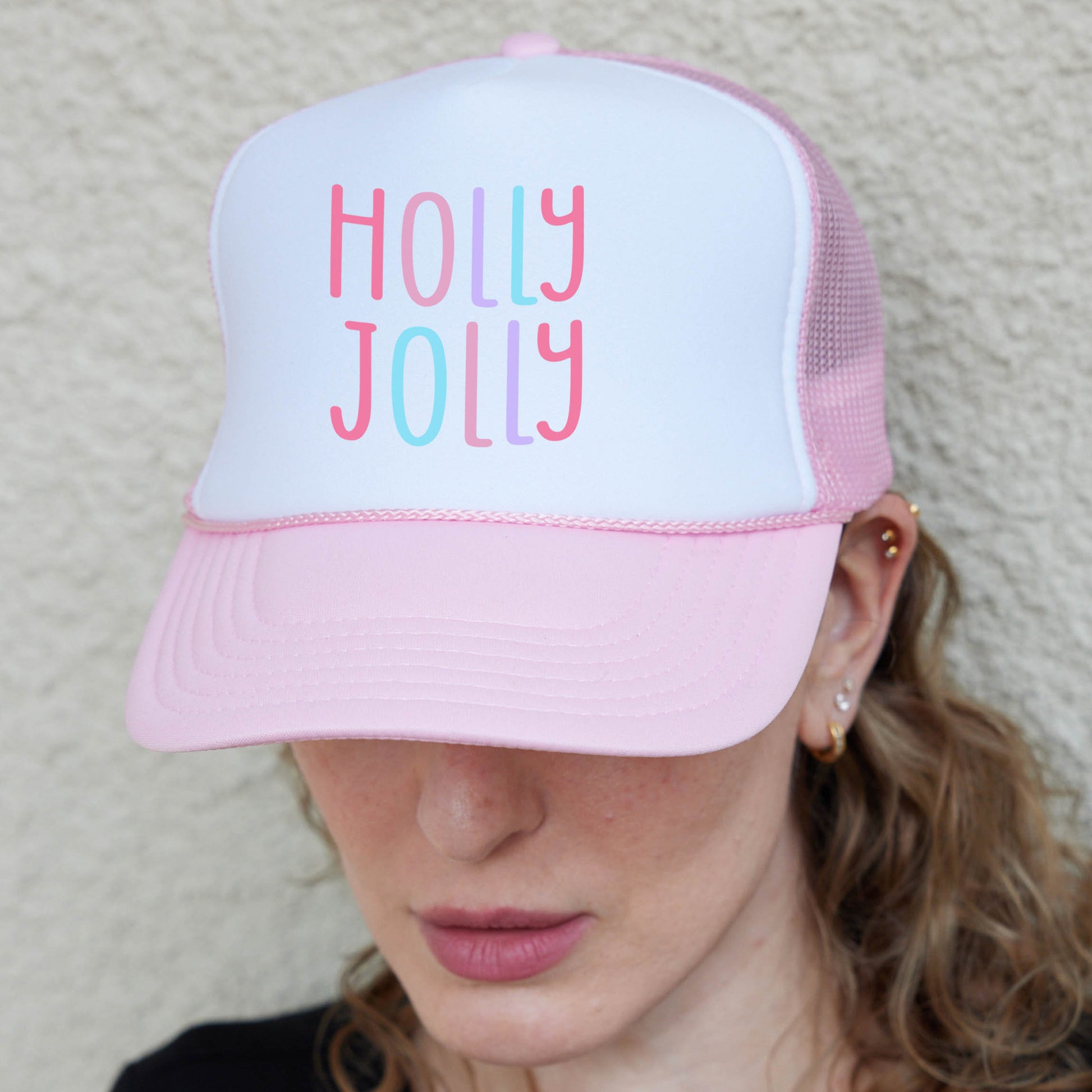 a woman wearing a pink and white trucker hat
