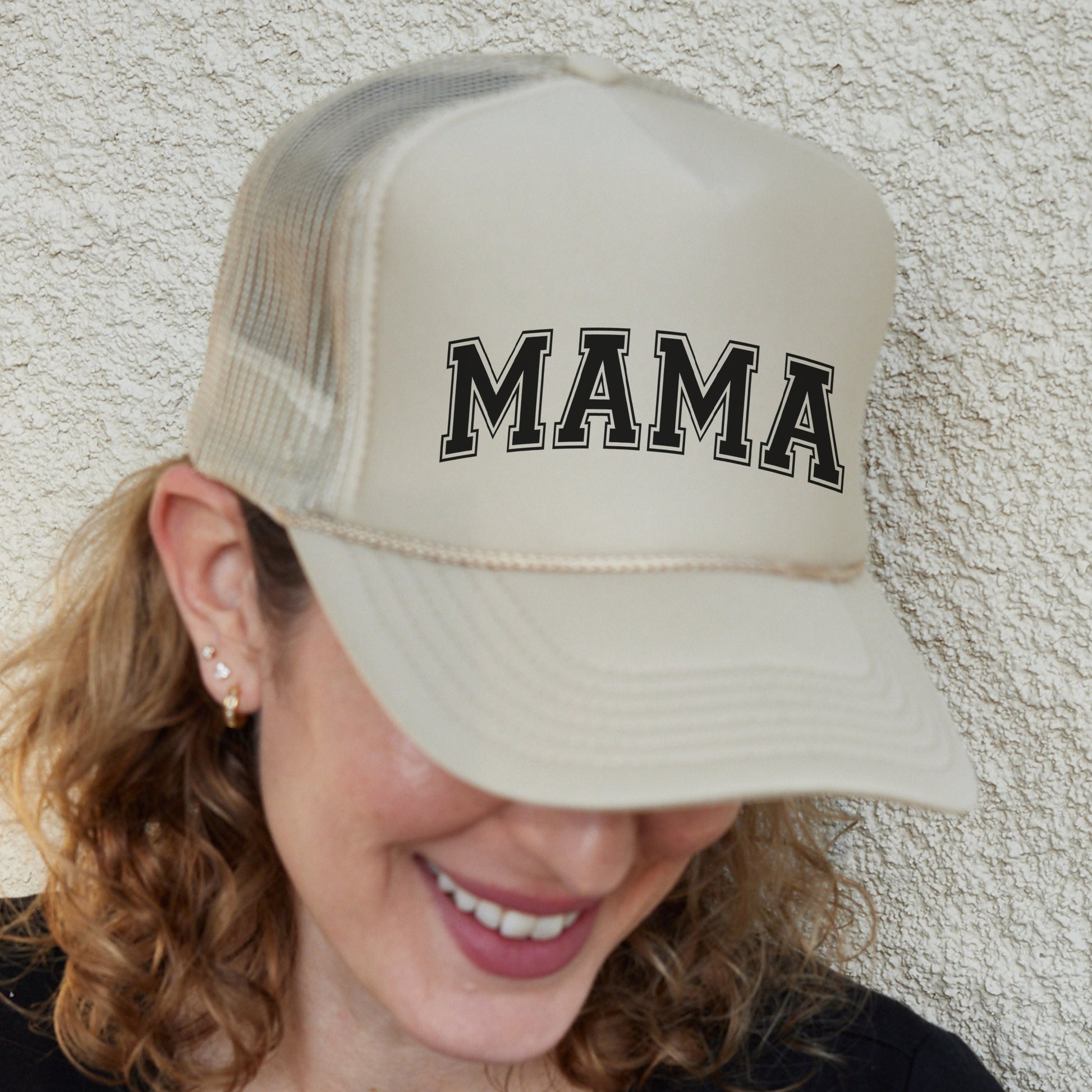 a woman wearing a hat with the word mama on it