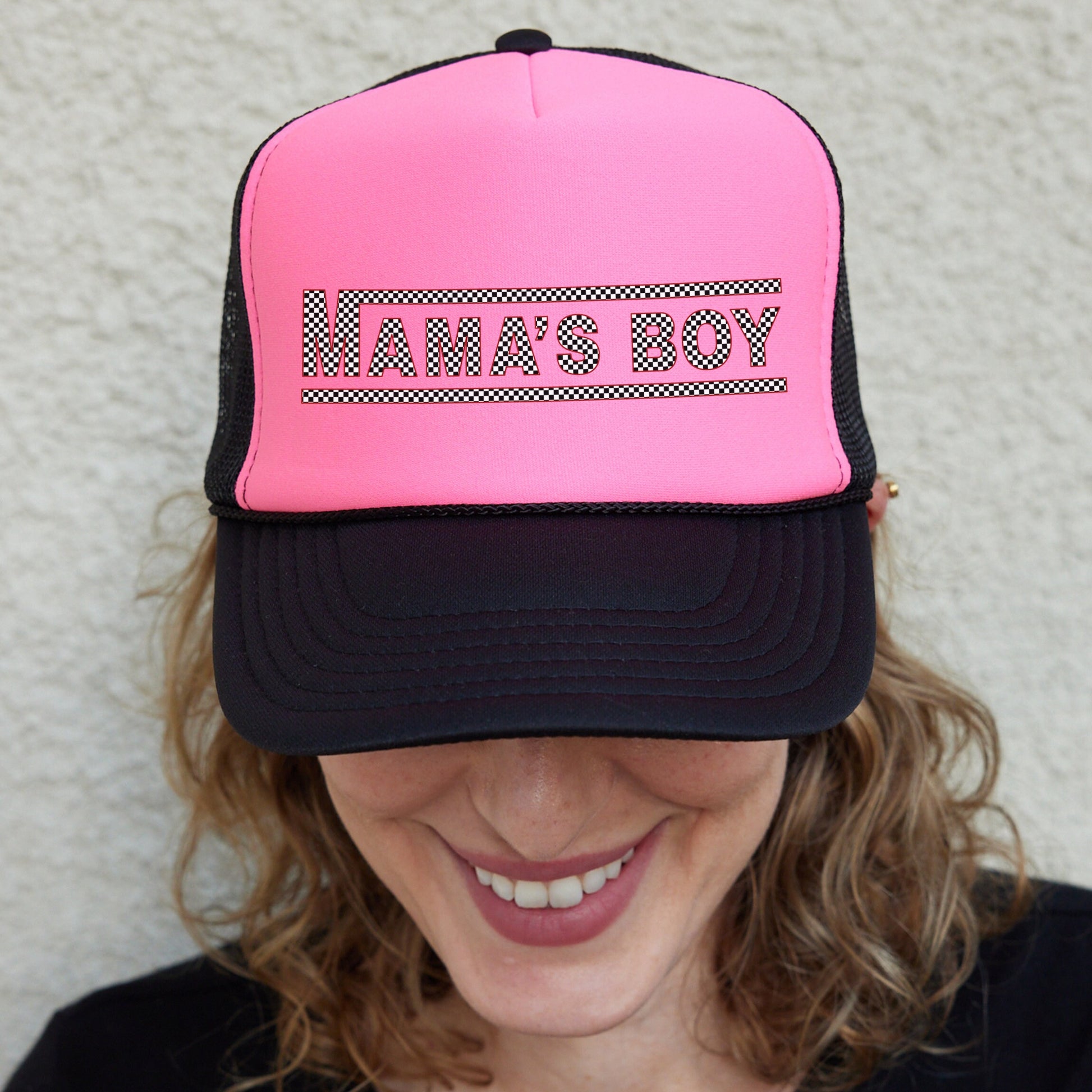 a woman wearing a pink and black trucker hat