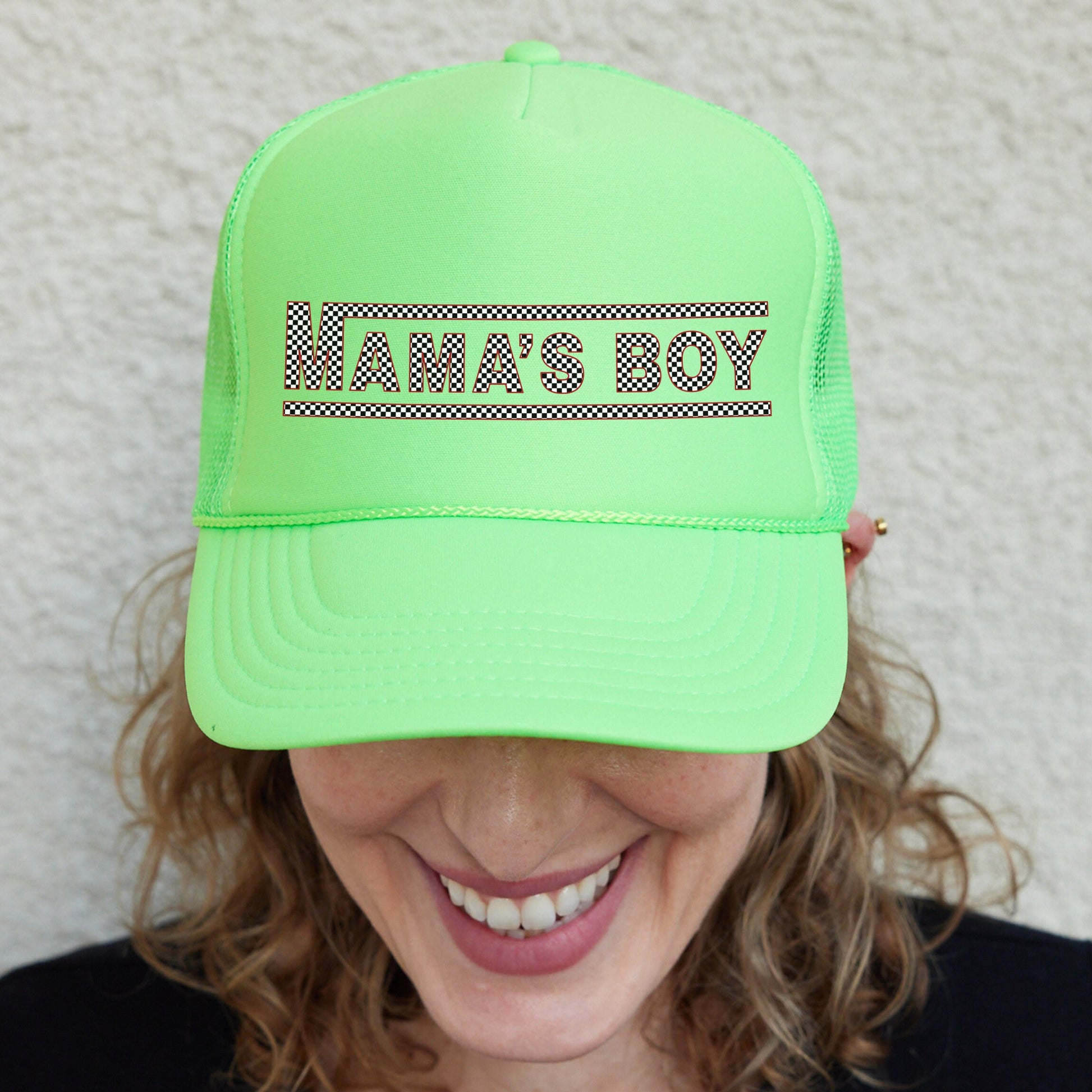 a smiling woman wearing a neon green hat