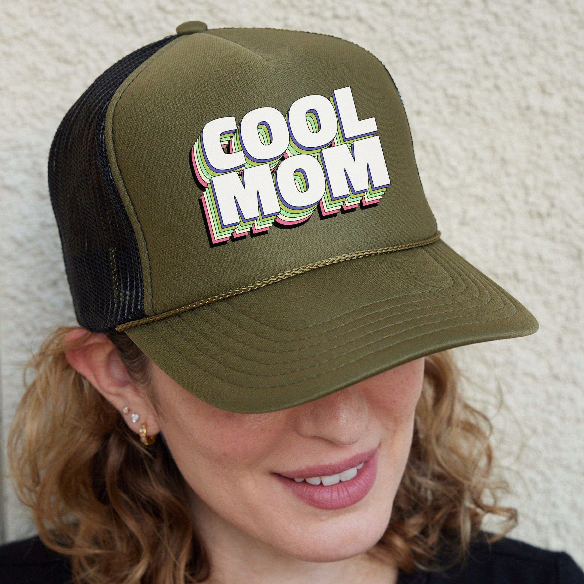 a woman wearing a trucker hat with the word cool mom on it