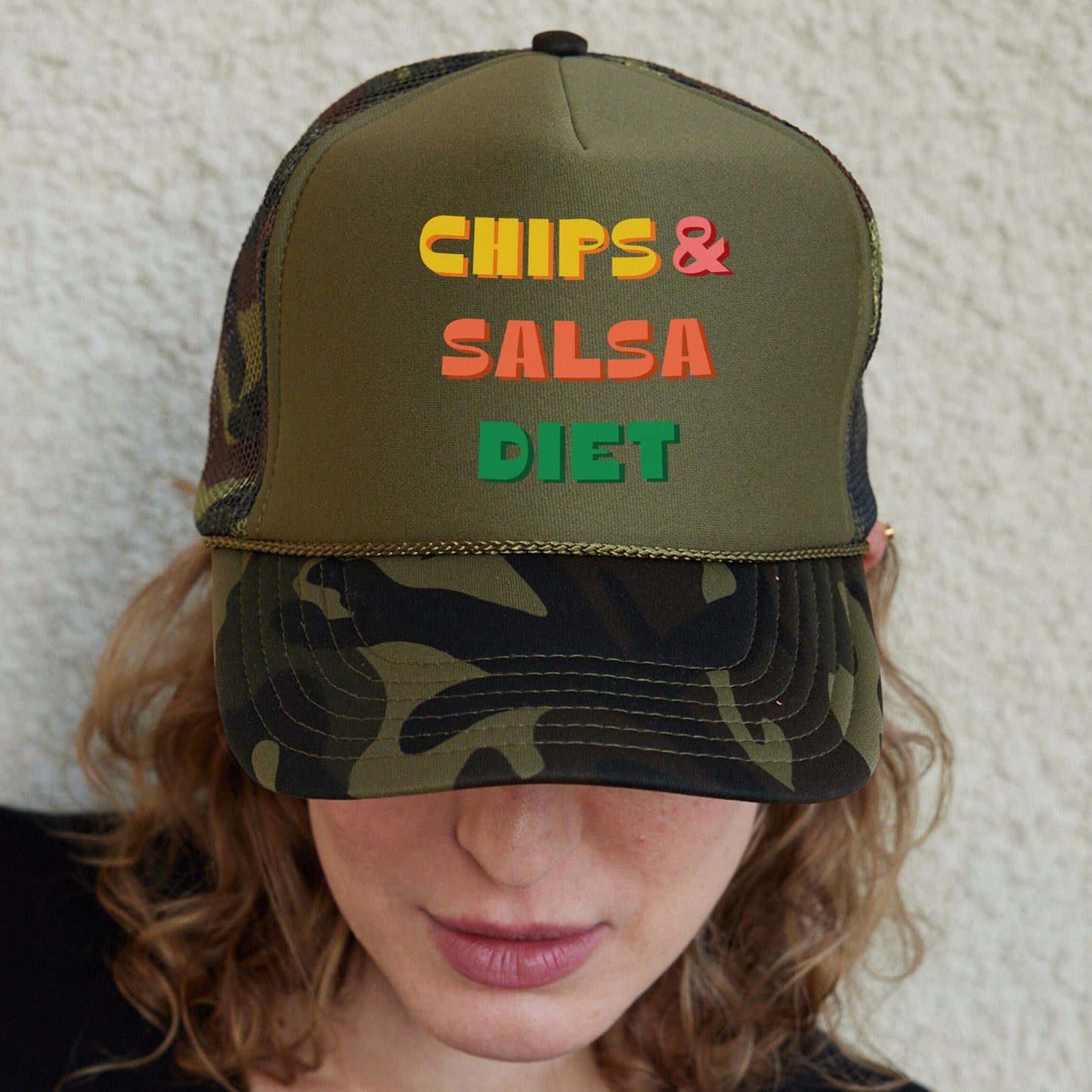 a woman wearing a camo hat that says chips and salsa diet