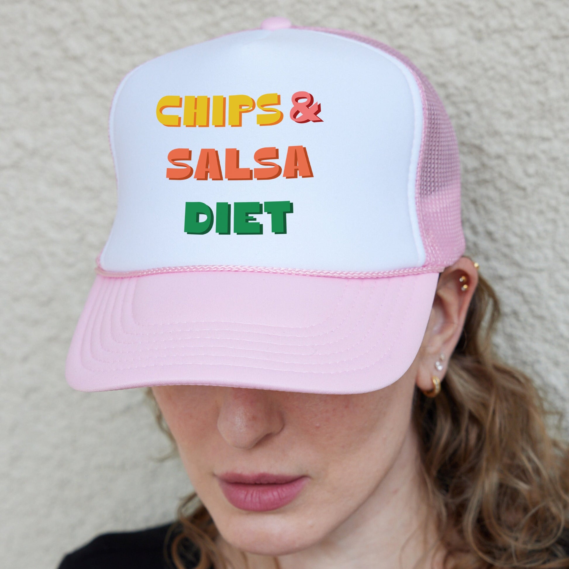 a woman wearing a pink and white hat with the words chips & salsa diet on