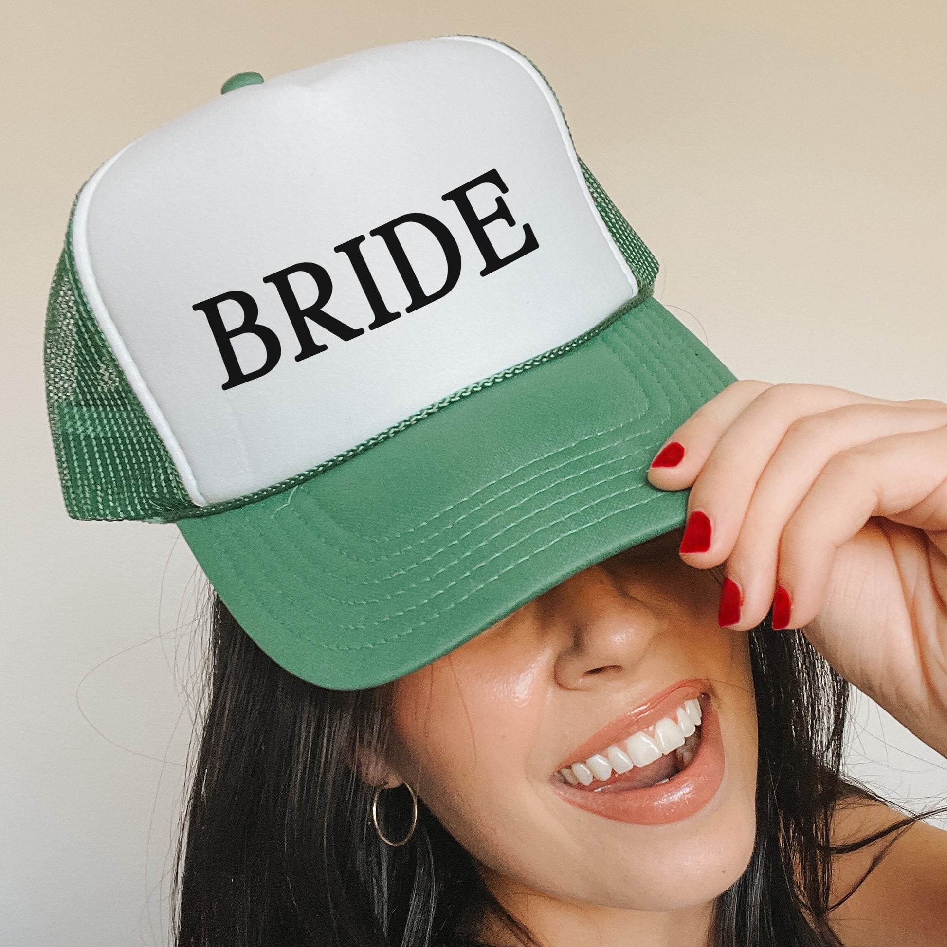 a woman wearing a green and white hat with the word bride on it