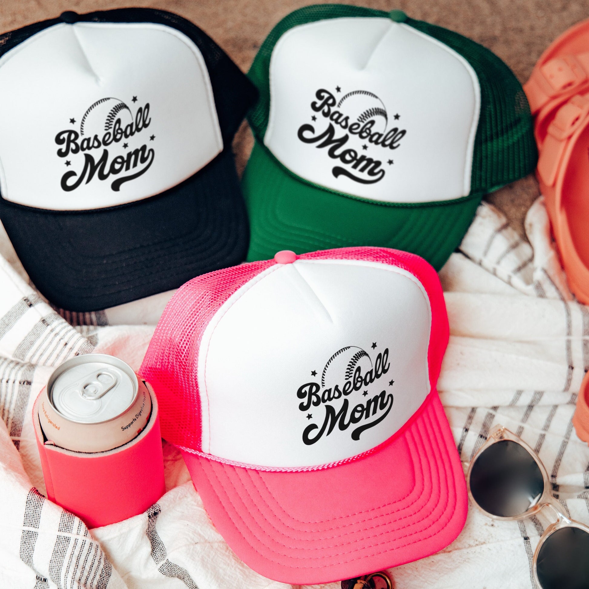 three hats and sunglasses are laying on a blanket