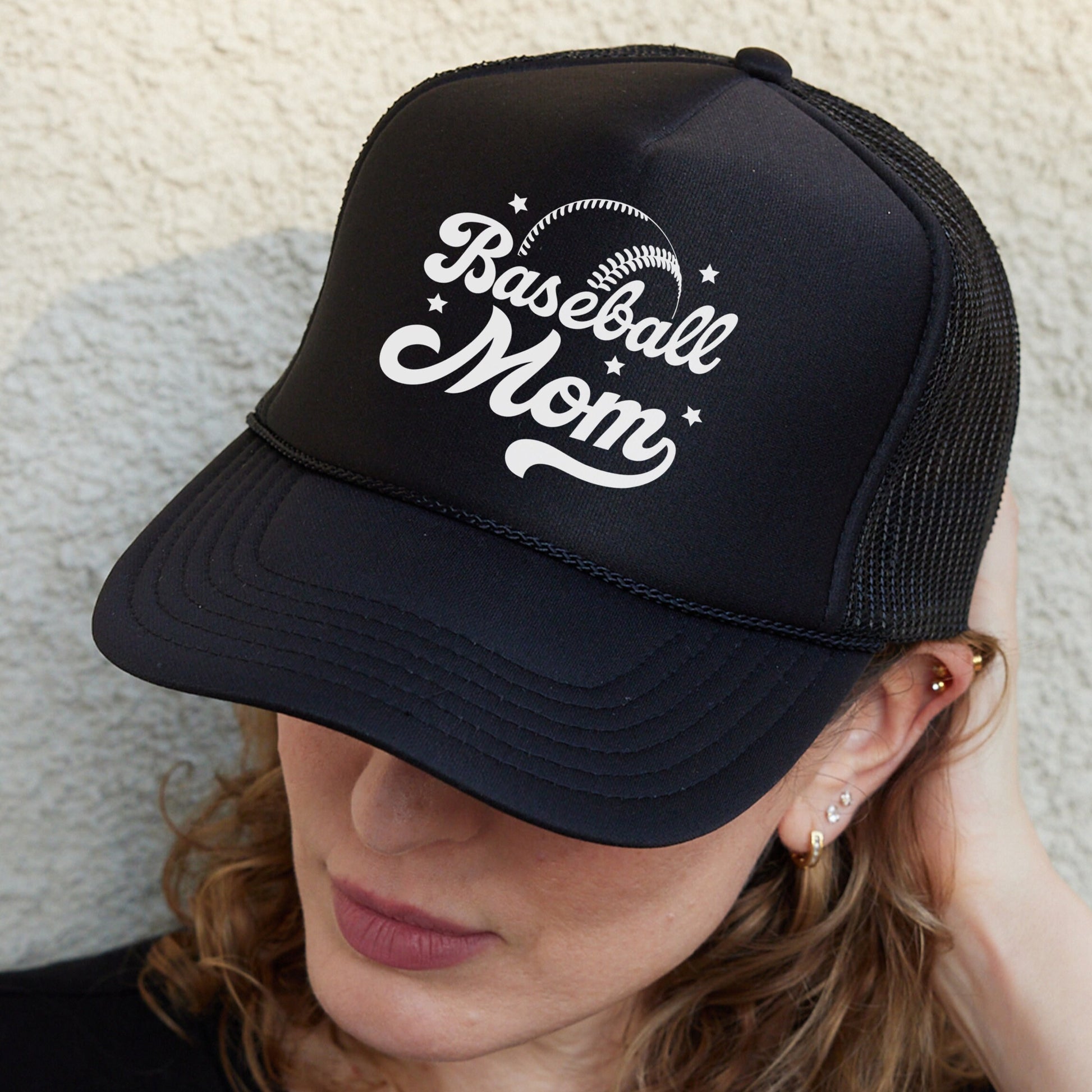a woman wearing a black baseball mom hat