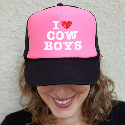 a woman wearing a pink and black trucker hat