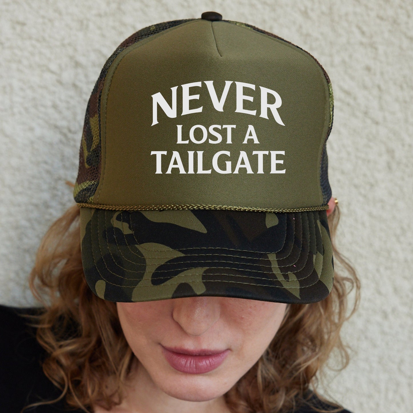 a woman wearing a hat that says never lost a tailgate