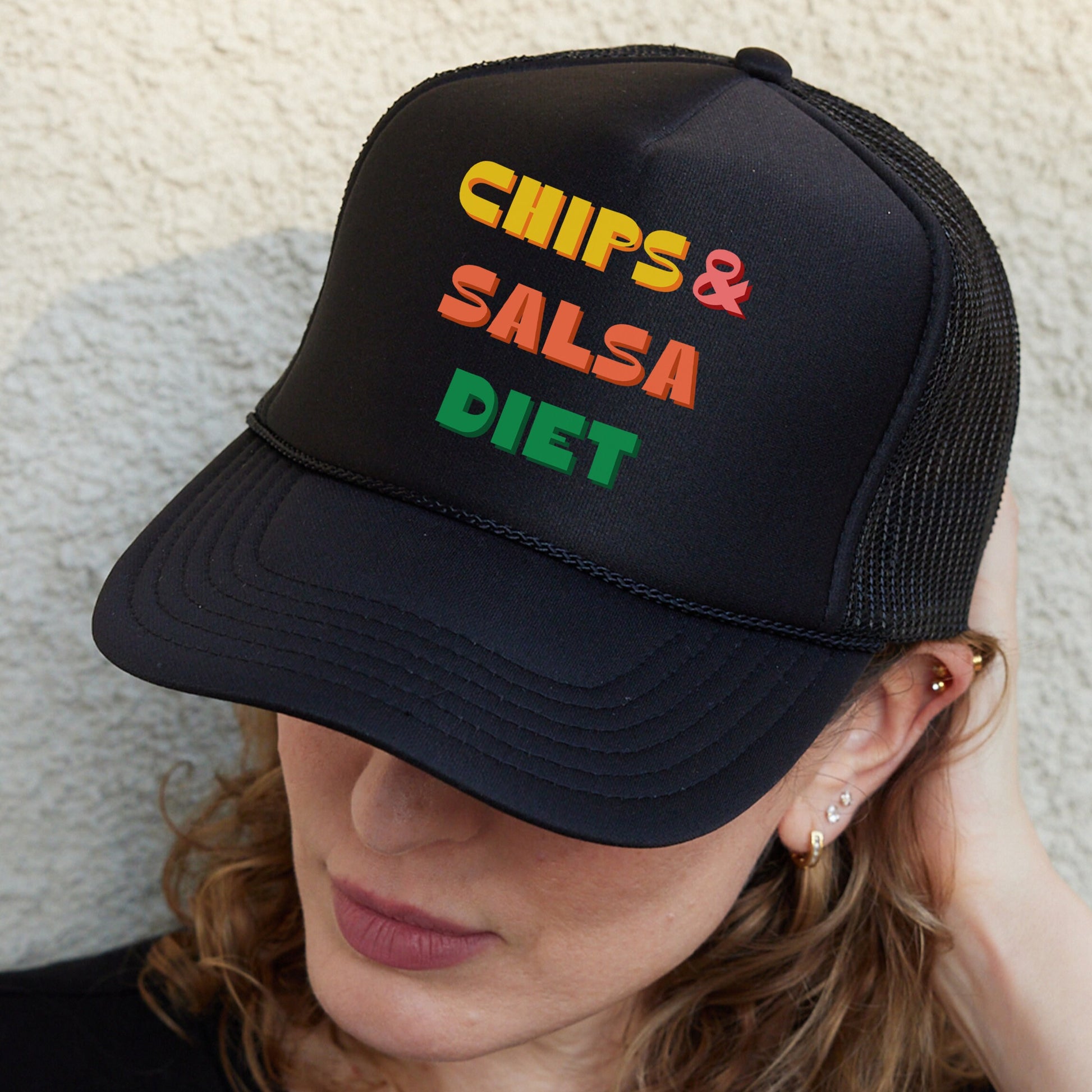 a woman wearing a black hat that says chips and salsa diet