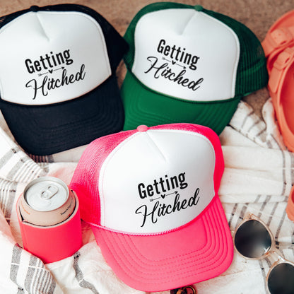 three hats sitting on top of a blanket next to sunglasses