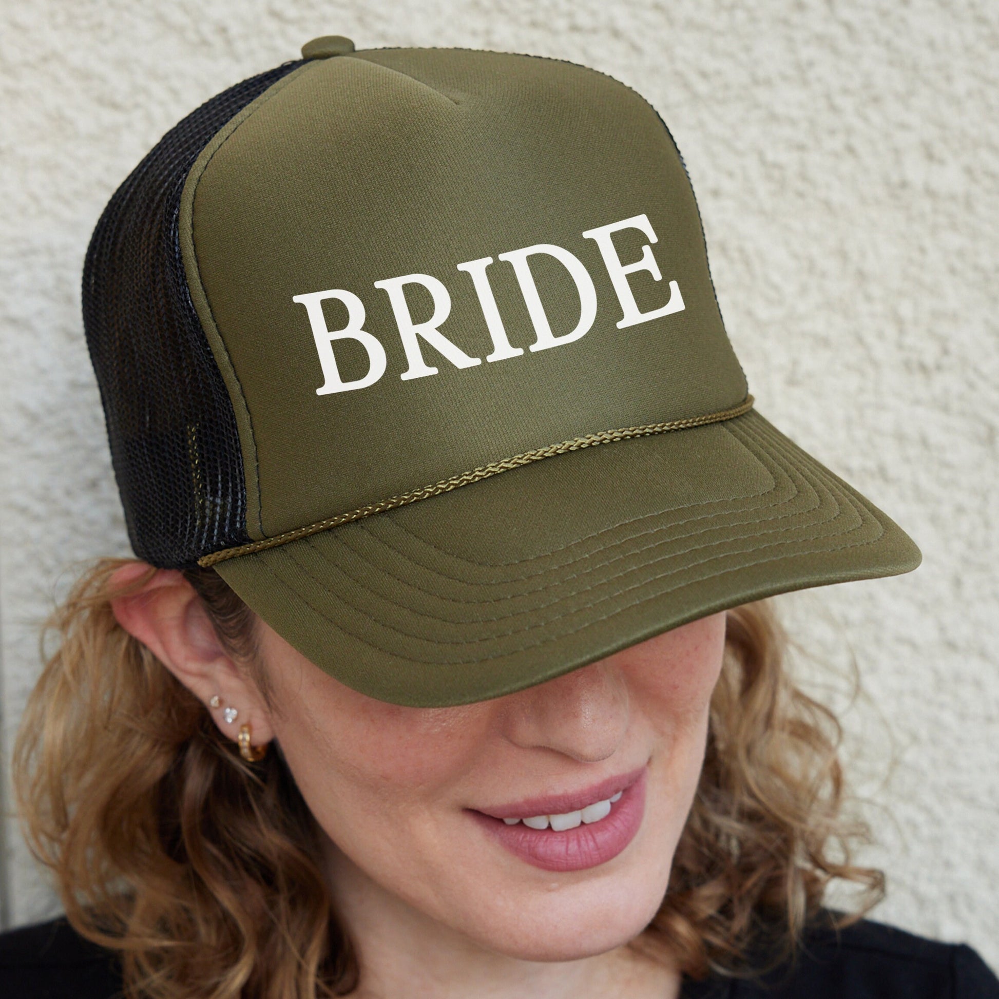 a woman wearing a trucker hat with the word bride on it