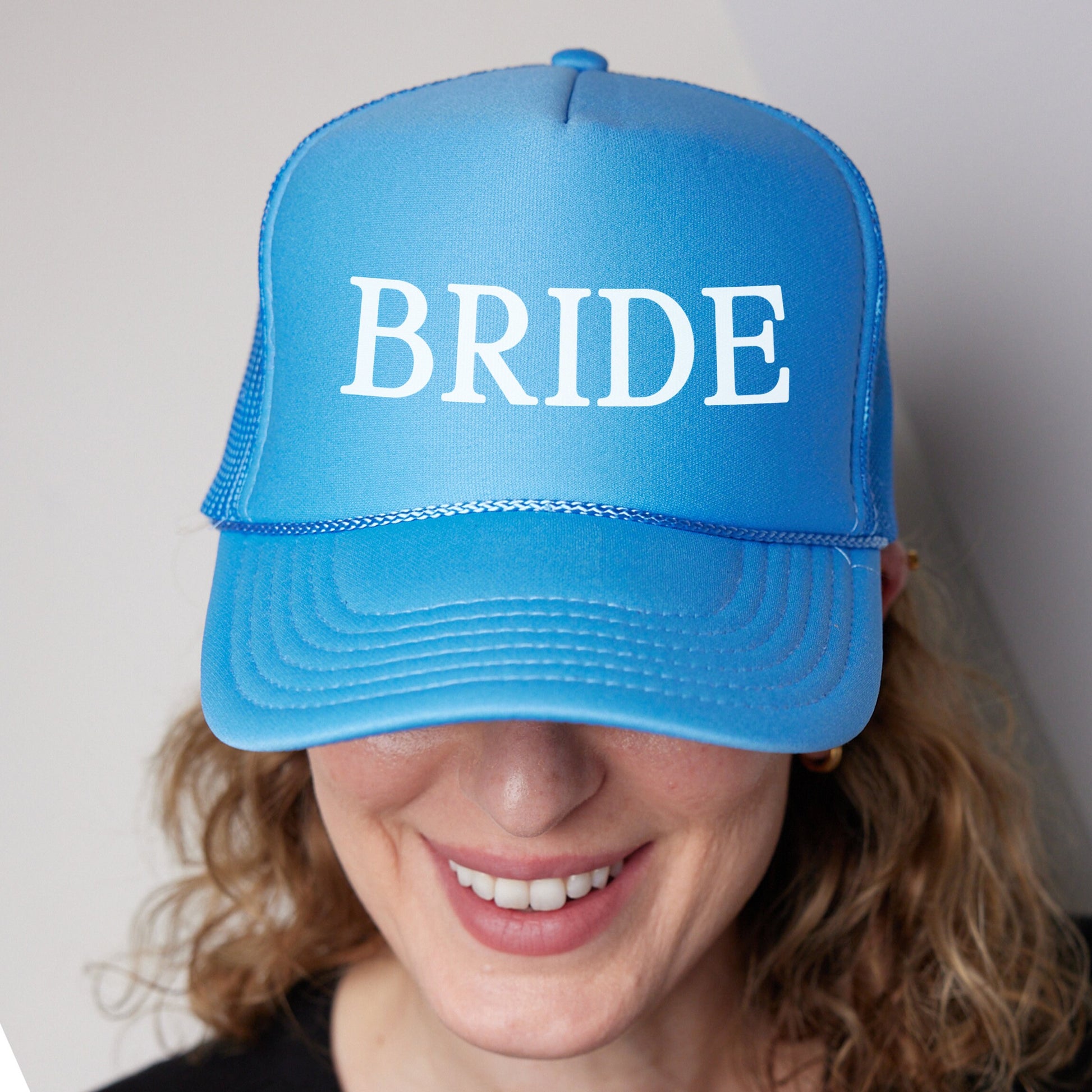 a woman wearing a blue hat with the word bride on it