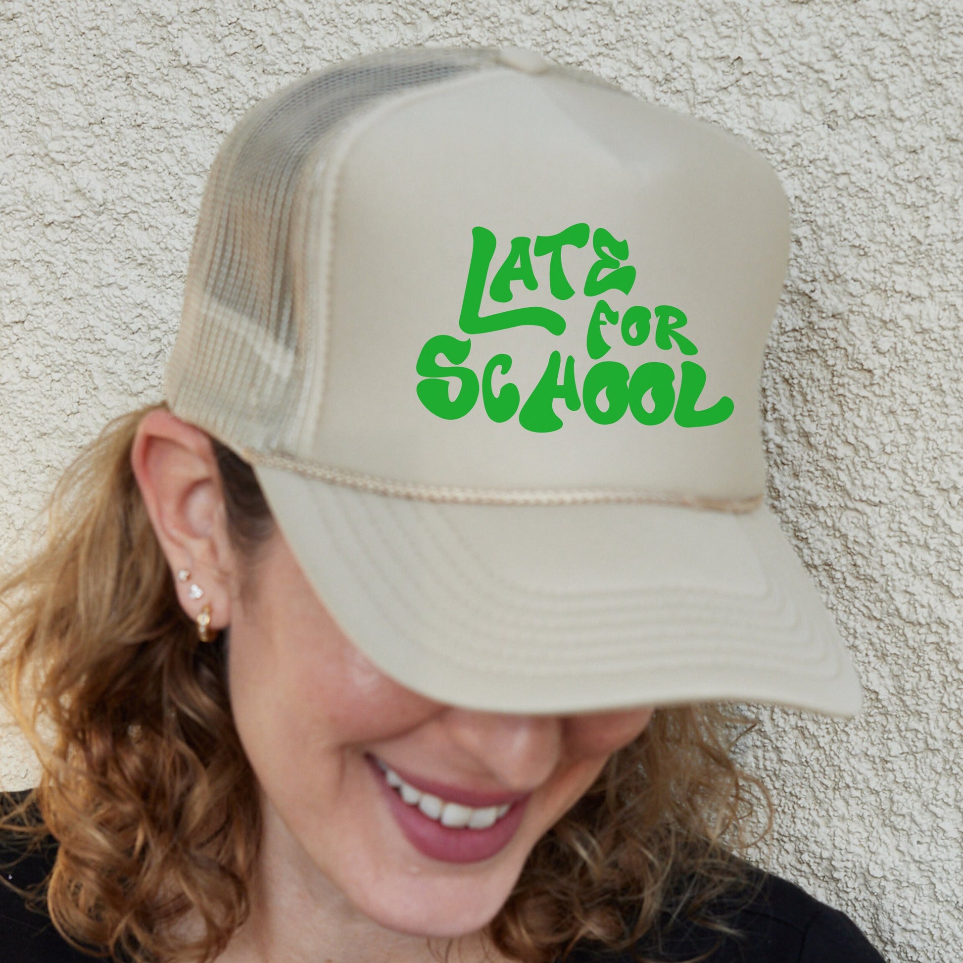 a woman wearing a hat that says late for school