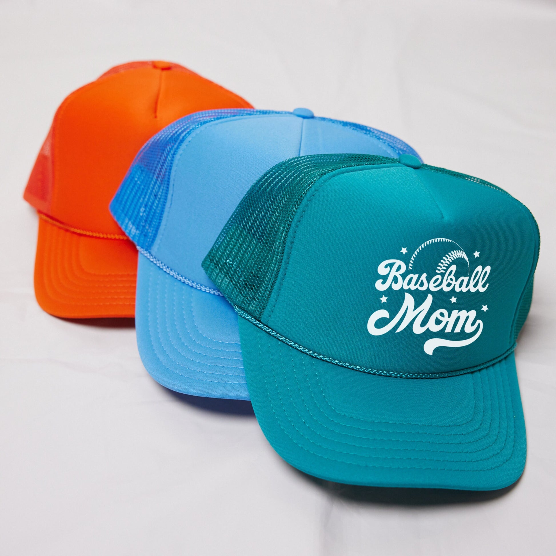 three different colored hats sitting on top of a white surface