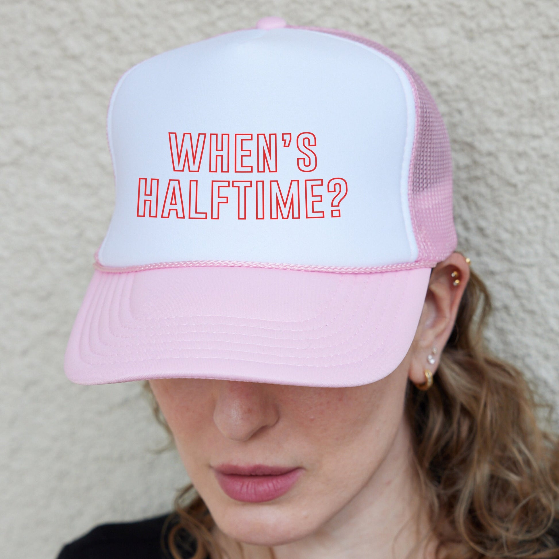 a woman wearing a pink and white hat with the words when&#39;s half time