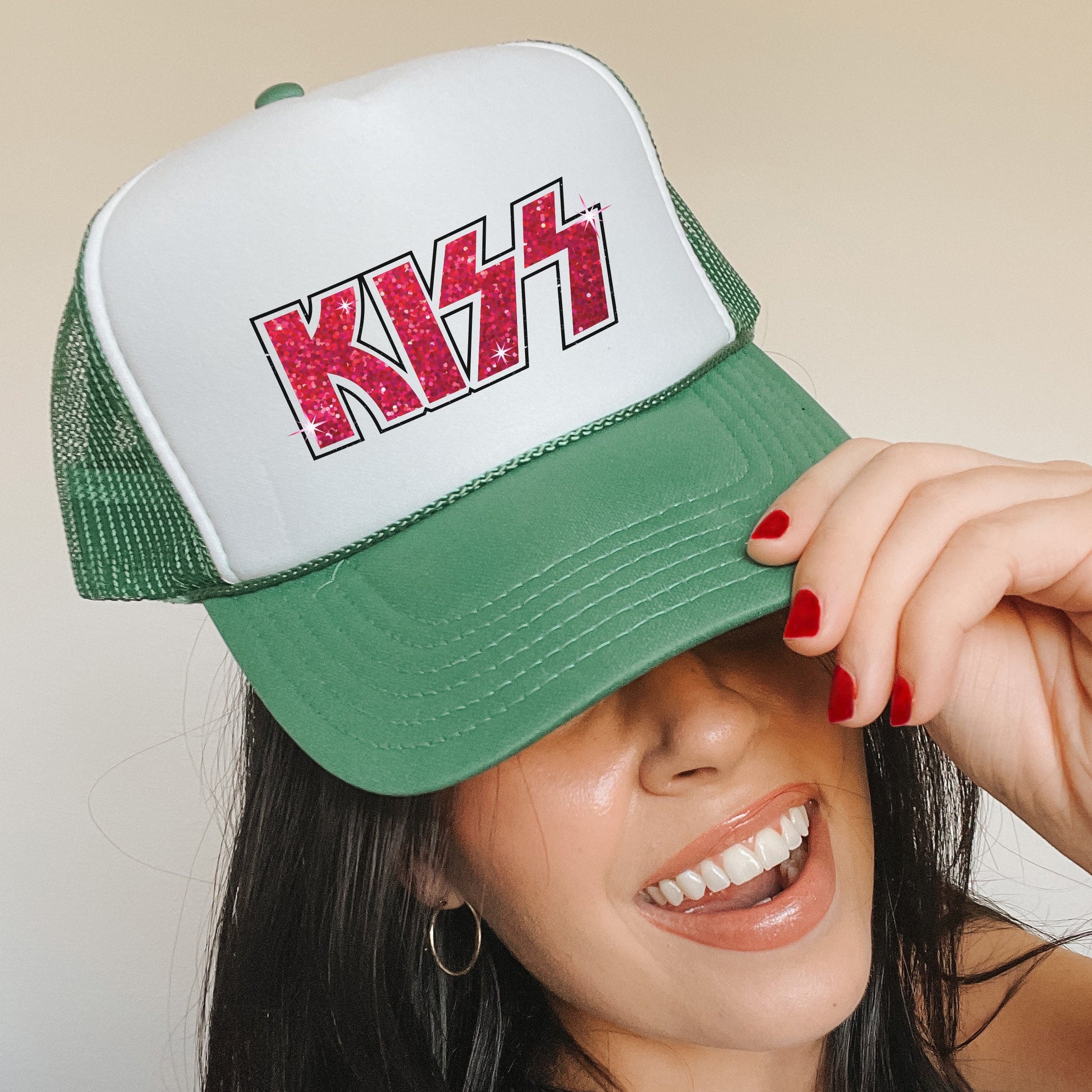 a woman wearing a green and white hat with the word kh on it