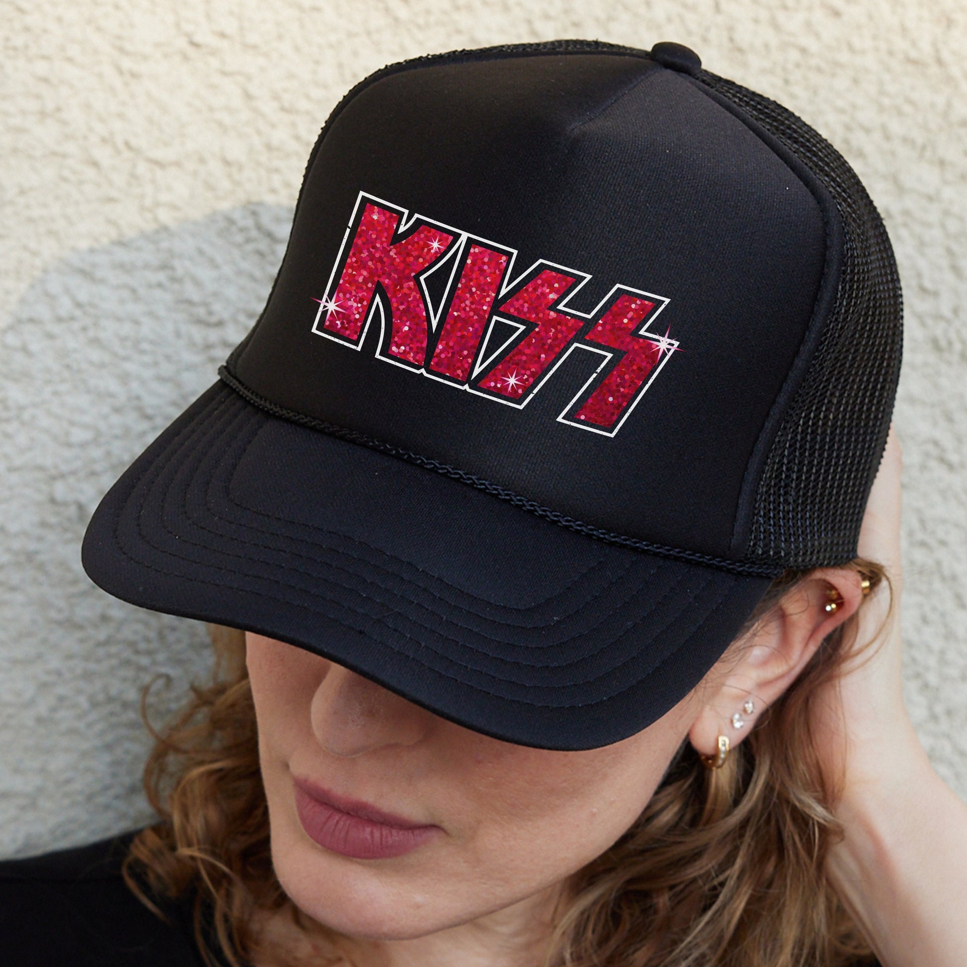 a woman wearing a black hat with red letters on it