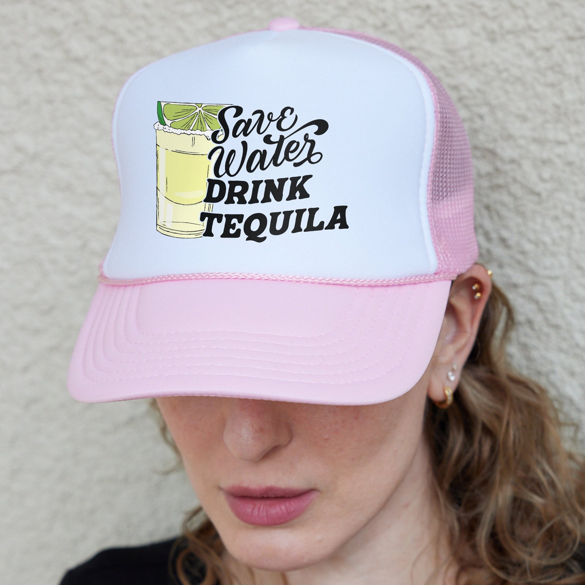 a woman wearing a pink and white trucker hat