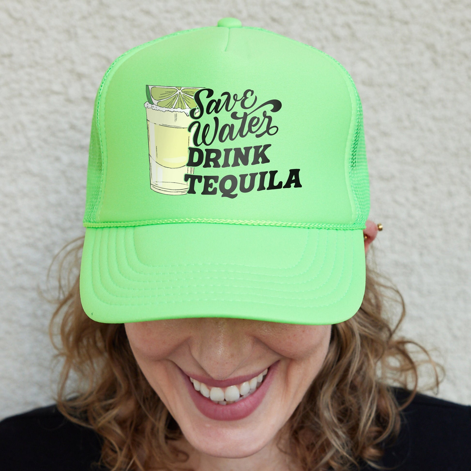 a woman wearing a green hat with a drink on it