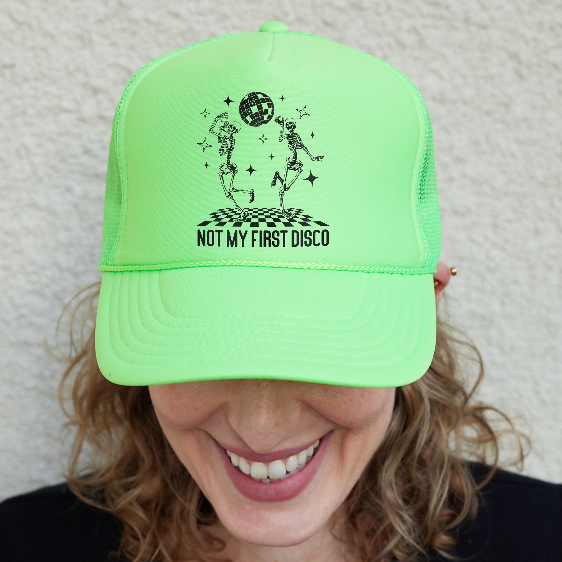 a smiling woman wearing a neon green hat
