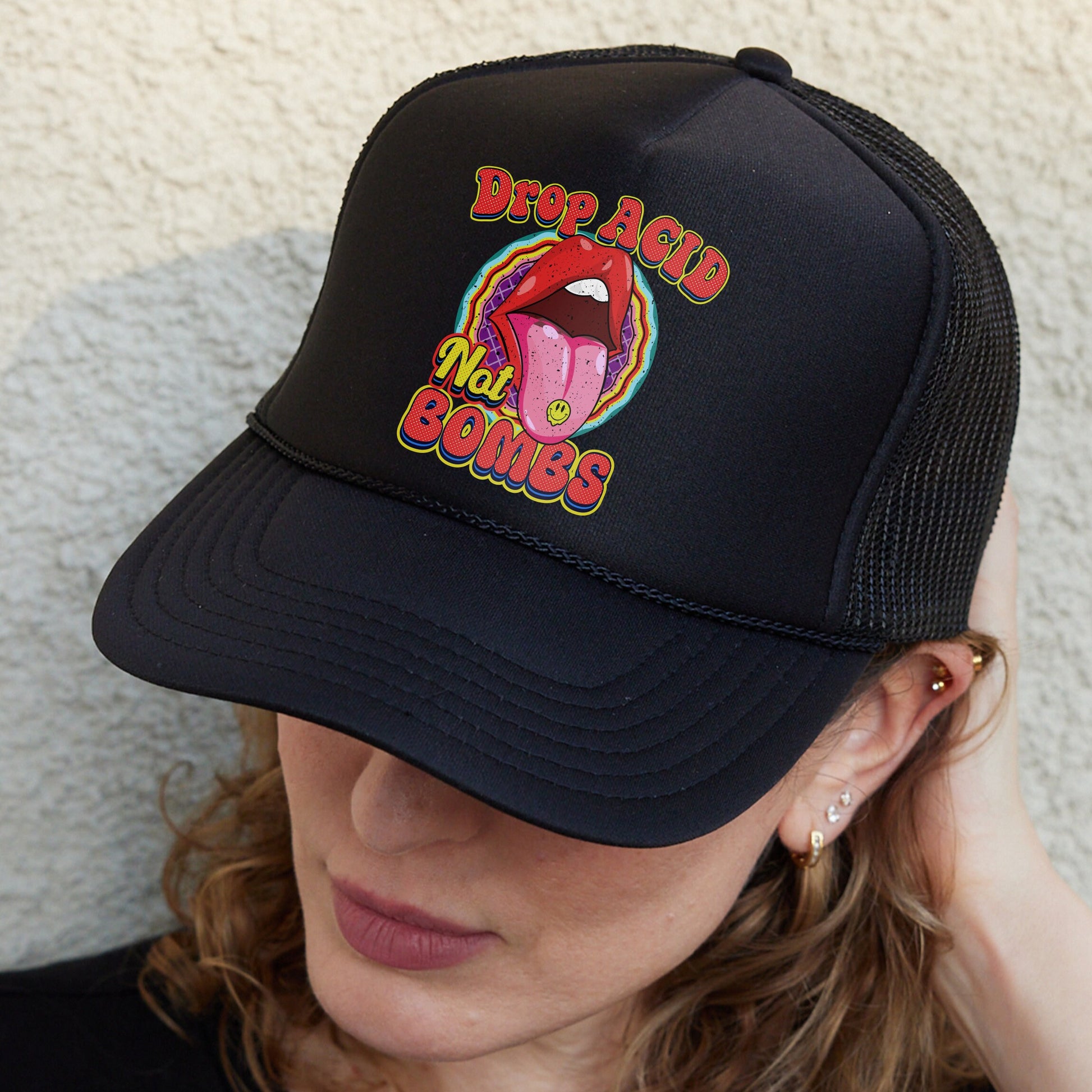 a woman wearing a black trucker hat with a tongue on it