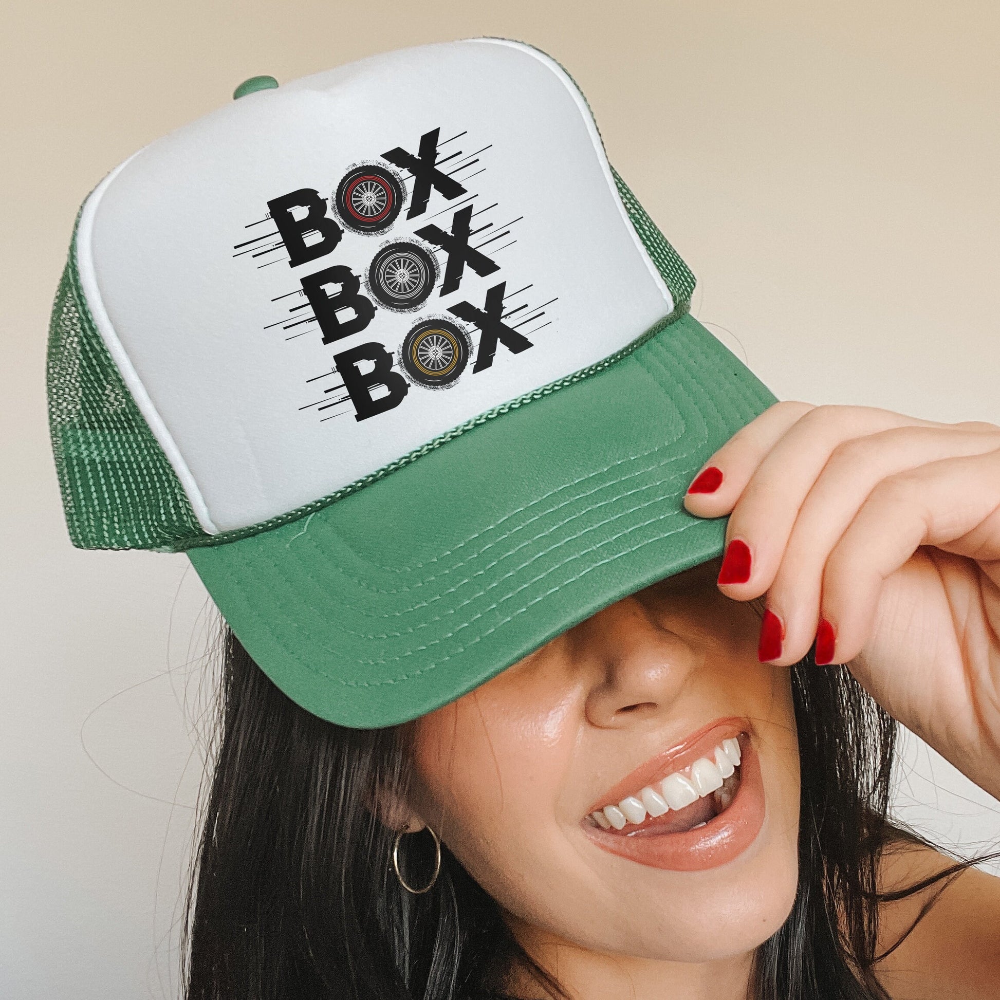 a woman wearing a green and white hat with the word box box on it