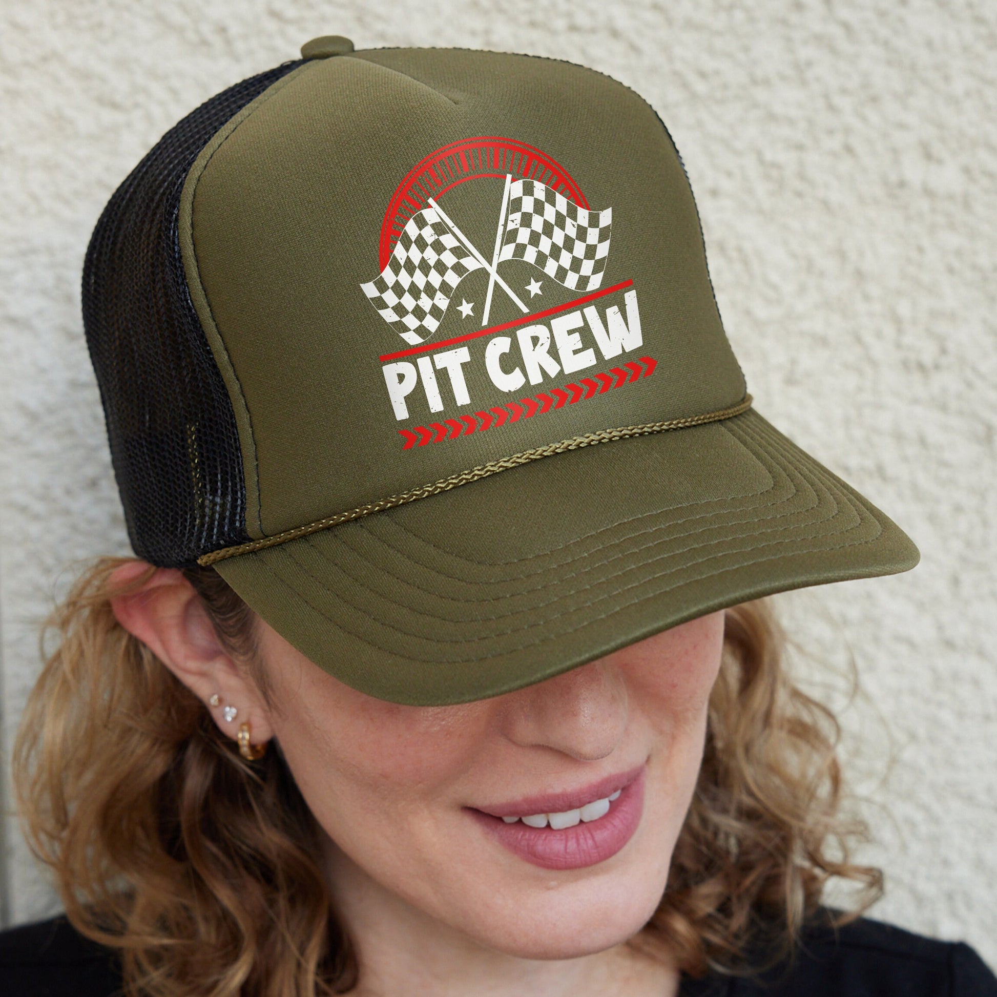 a woman wearing a trucker hat that says pit crew