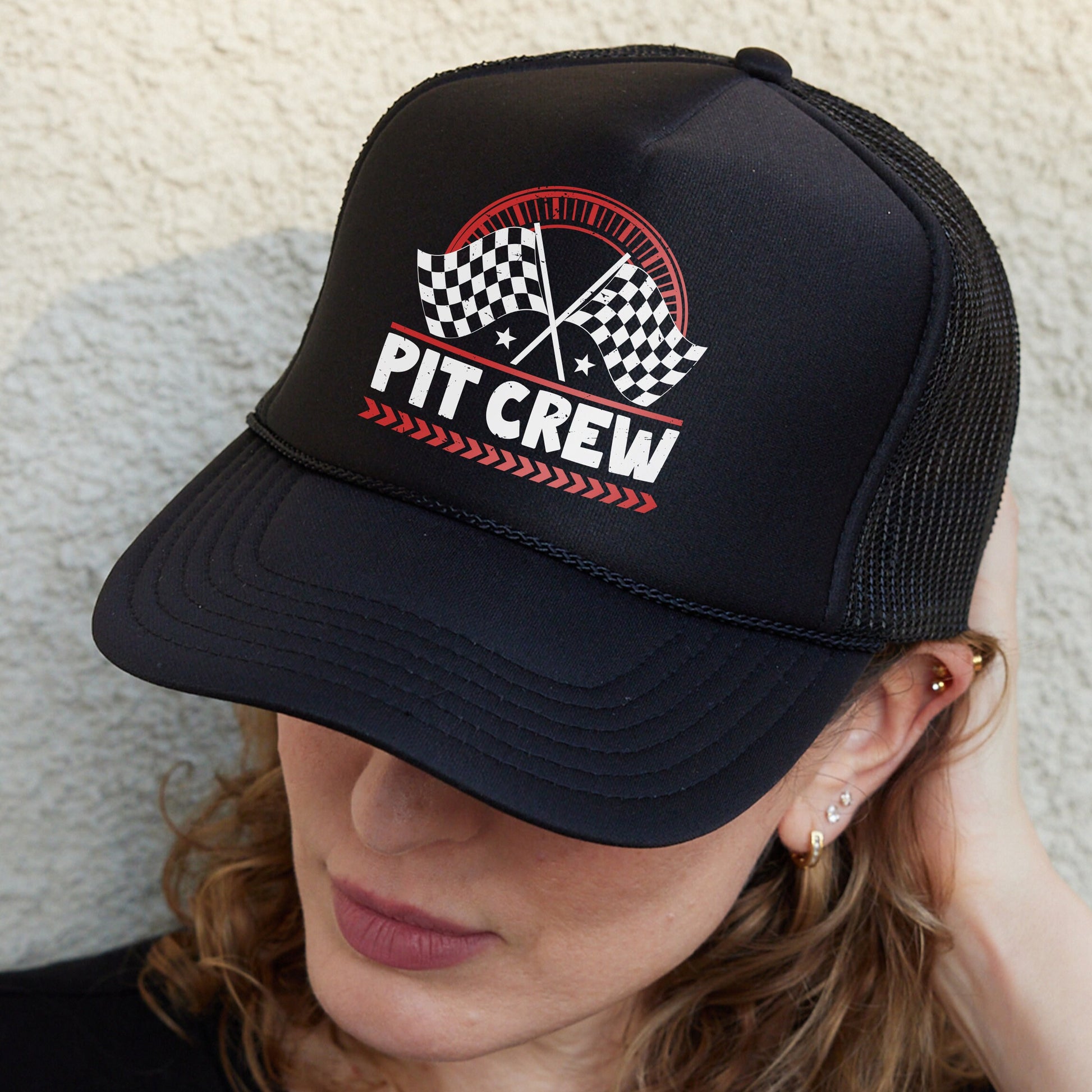 a woman wearing a hat with a pit crew design on it