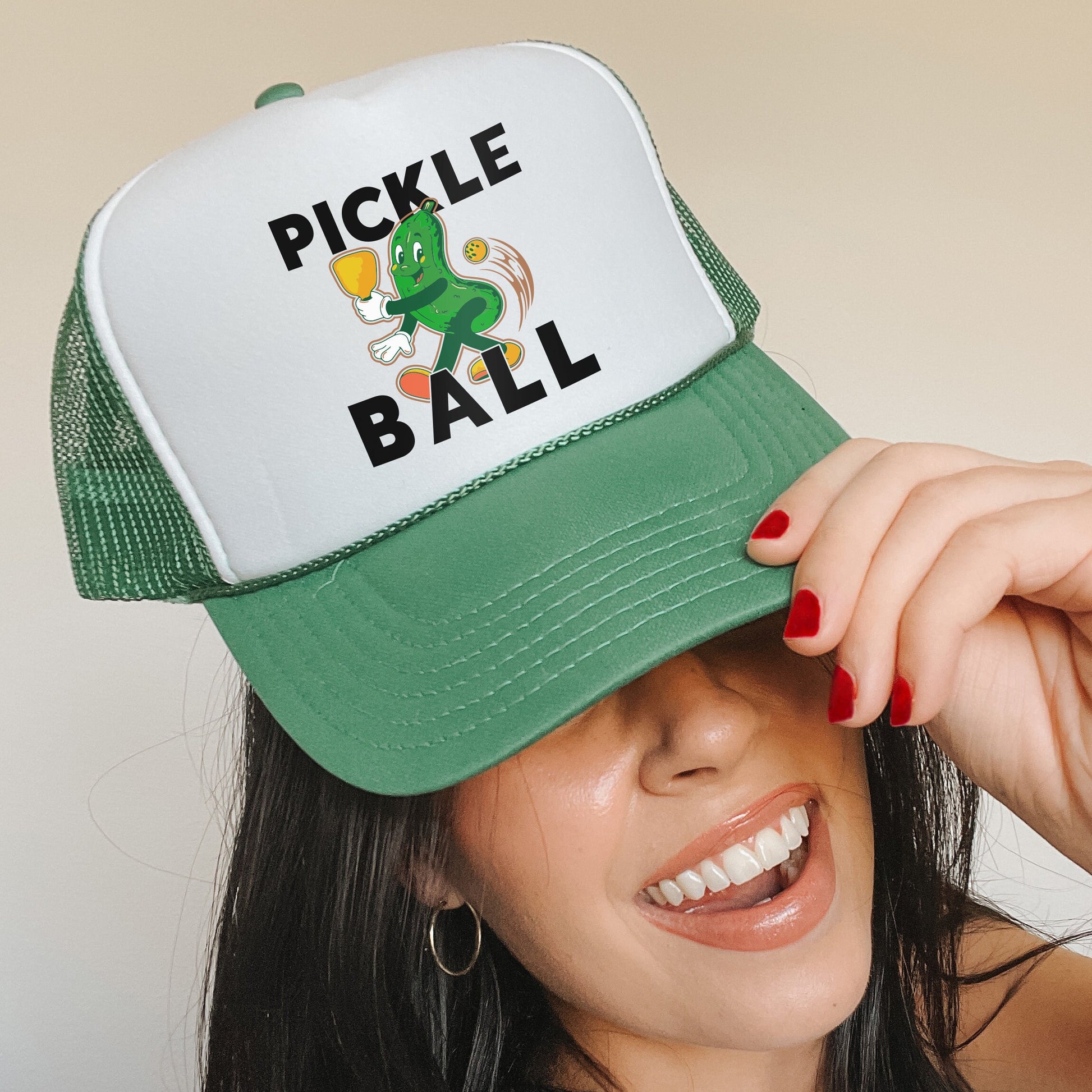 a woman wearing a green and white pickle ball hat