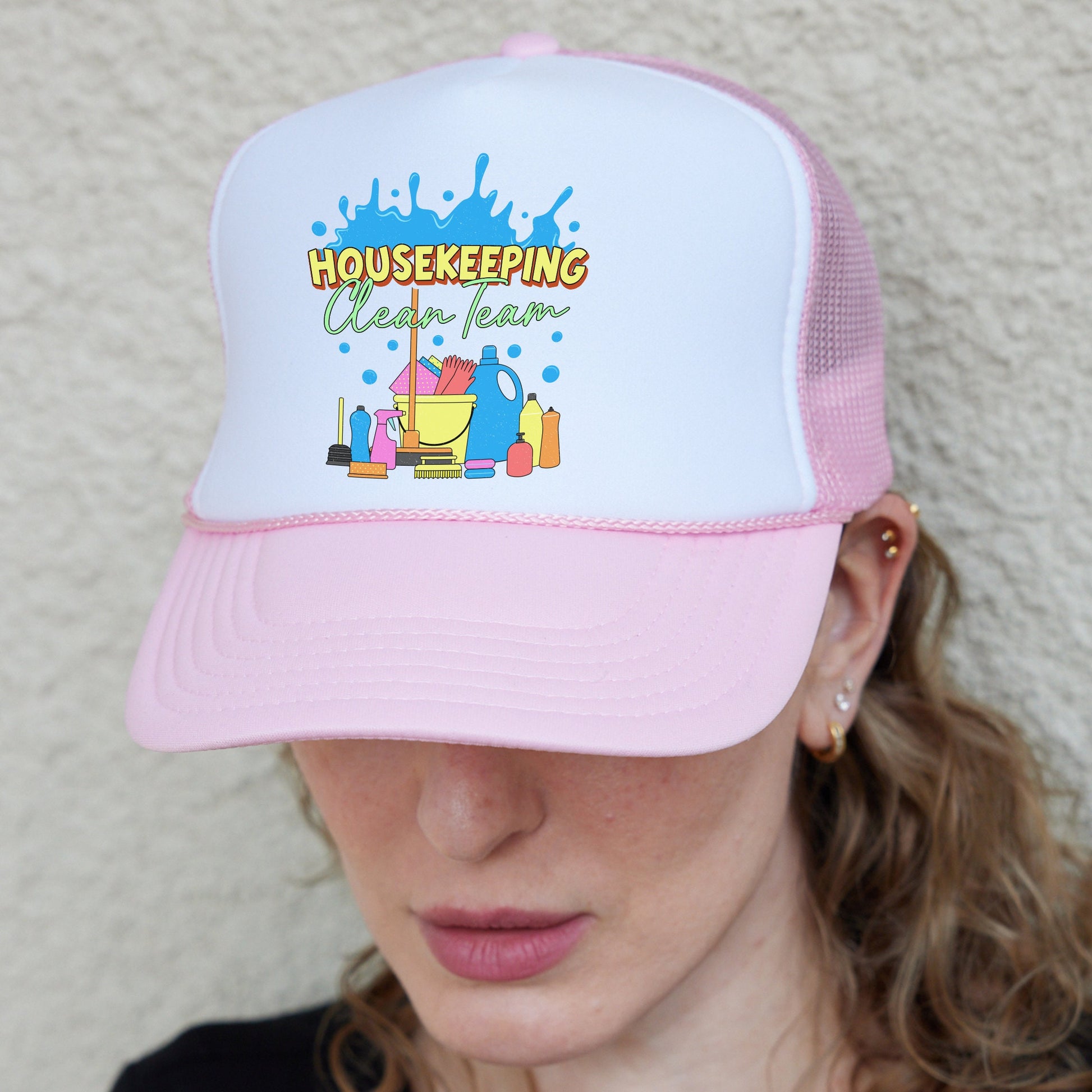 a woman wearing a pink and white trucker hat