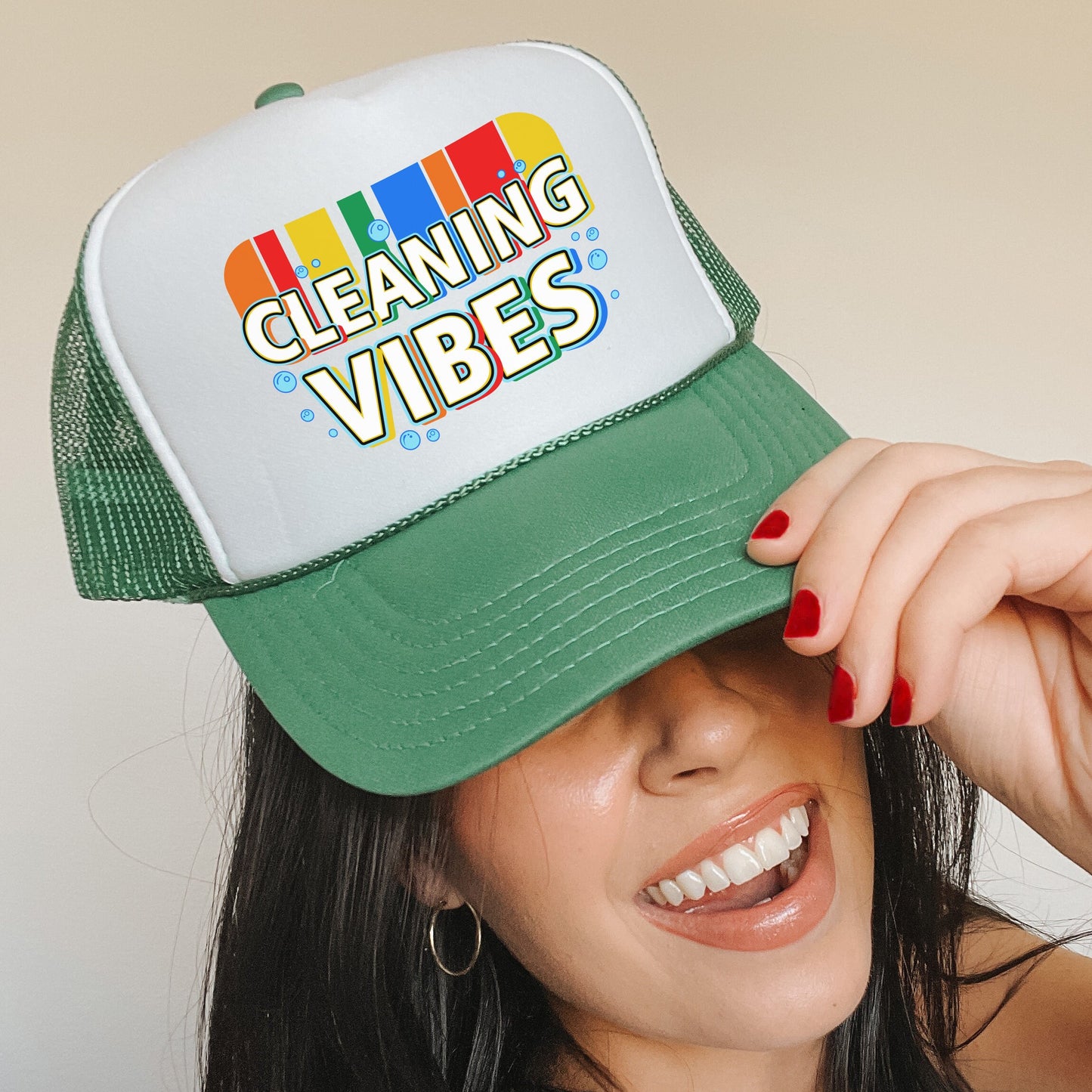 a woman wearing a green and white cleaning vibes hat