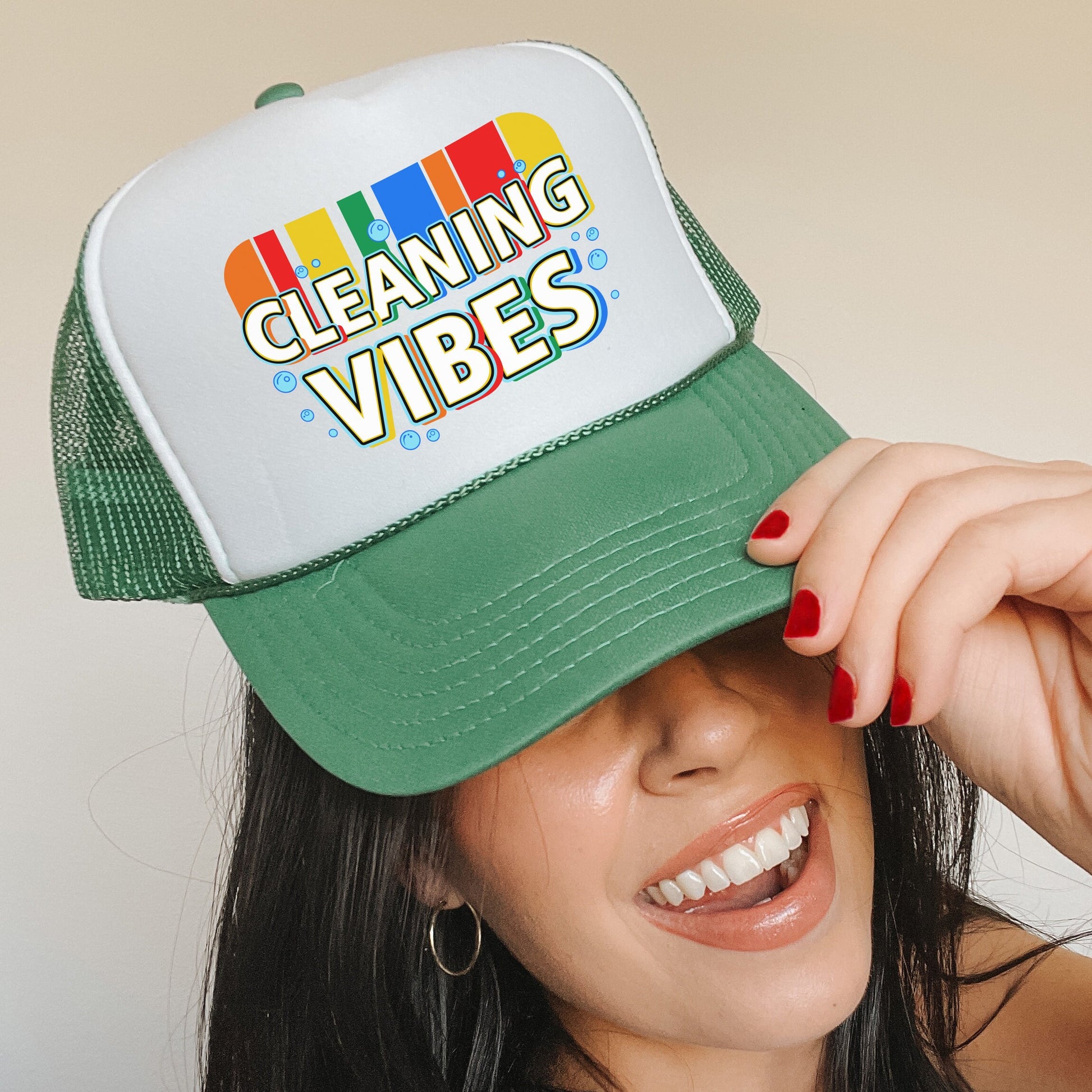 a woman wearing a green and white cleaning vibes hat