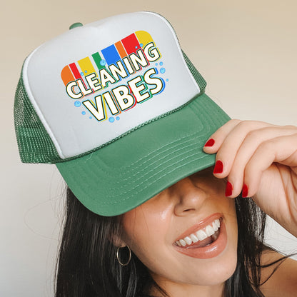 a woman wearing a green and white cleaning vibes hat