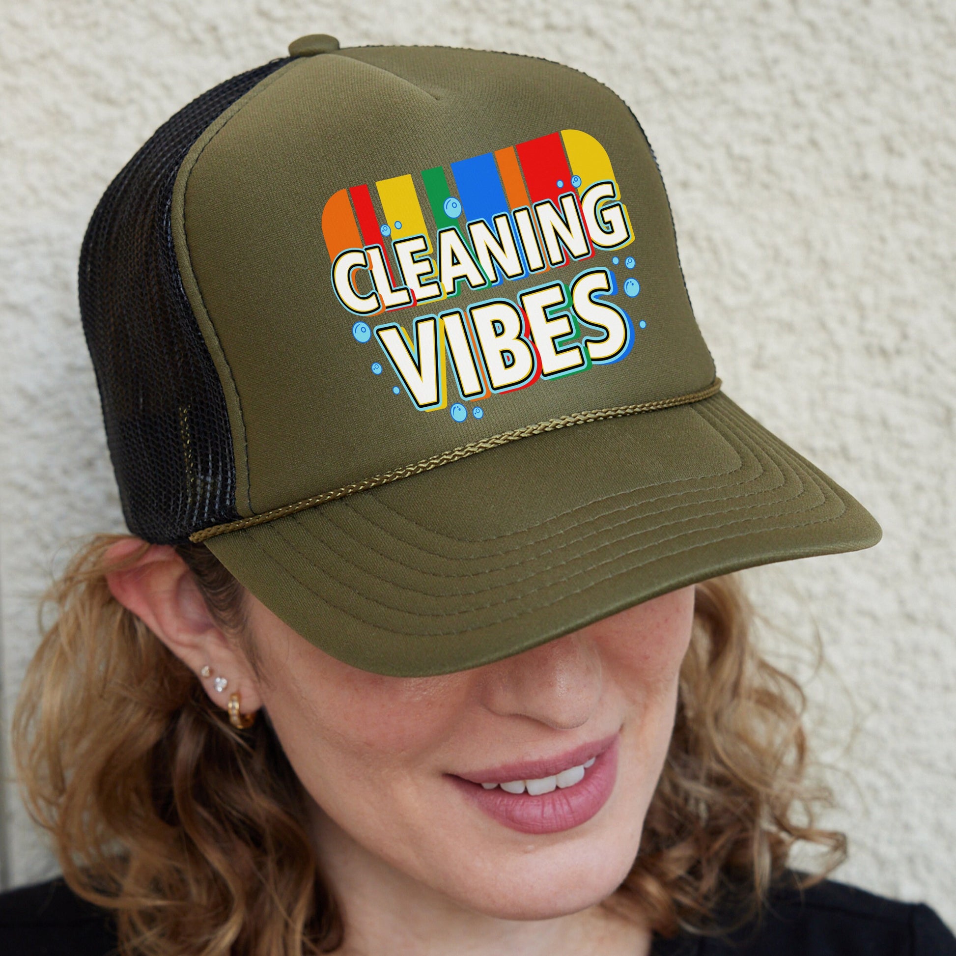 a woman wearing a trucker hat that says cleaning vibes